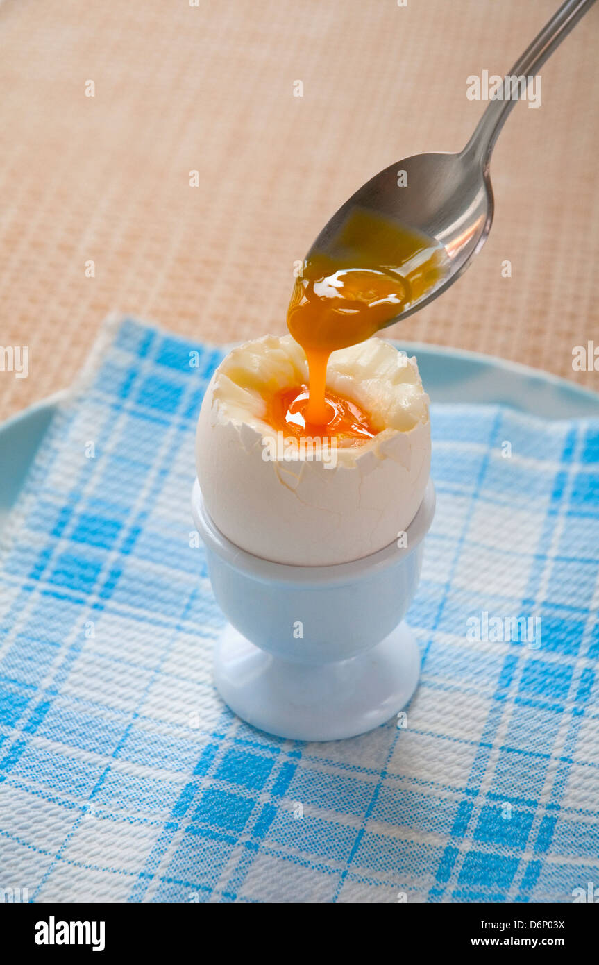 Soft boiled egg in an egg cup with spoon. Close view Stock Photo - Alamy