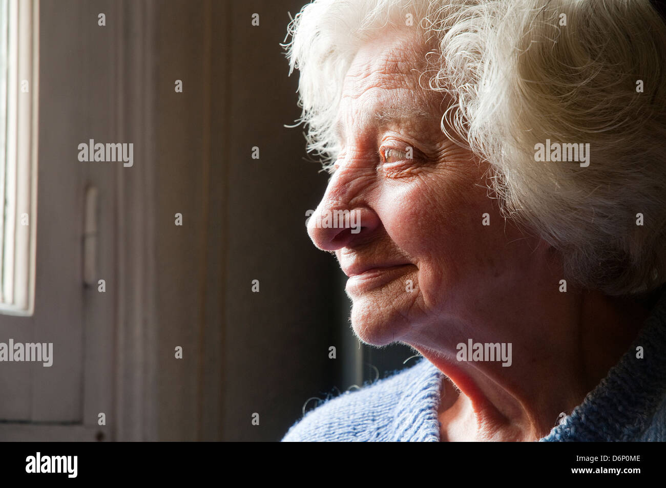 Profile portrait of old woman smiling. Close view. Stock Photo