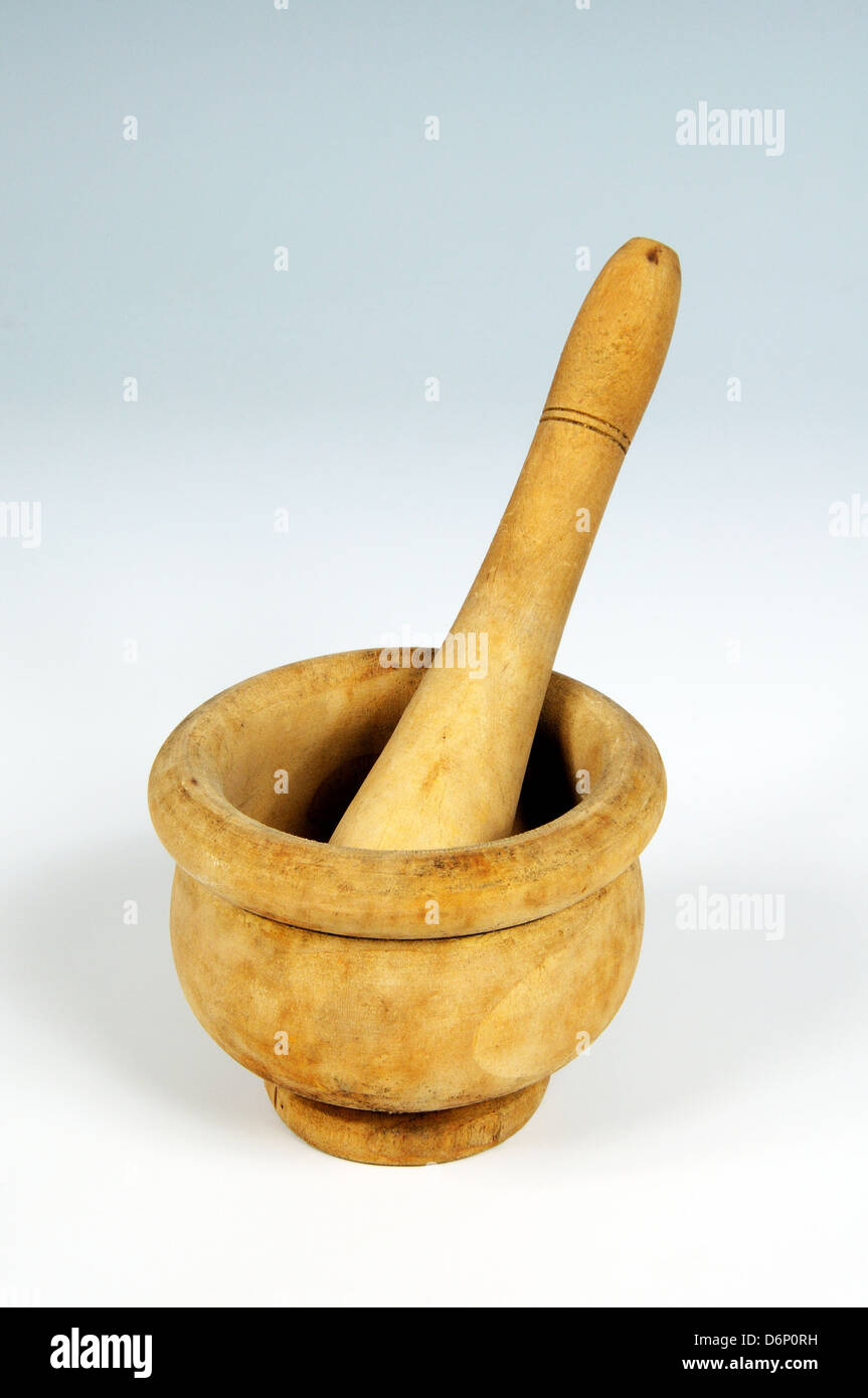 Wooden pestle and mortar against a plain background Stock Photo - Alamy