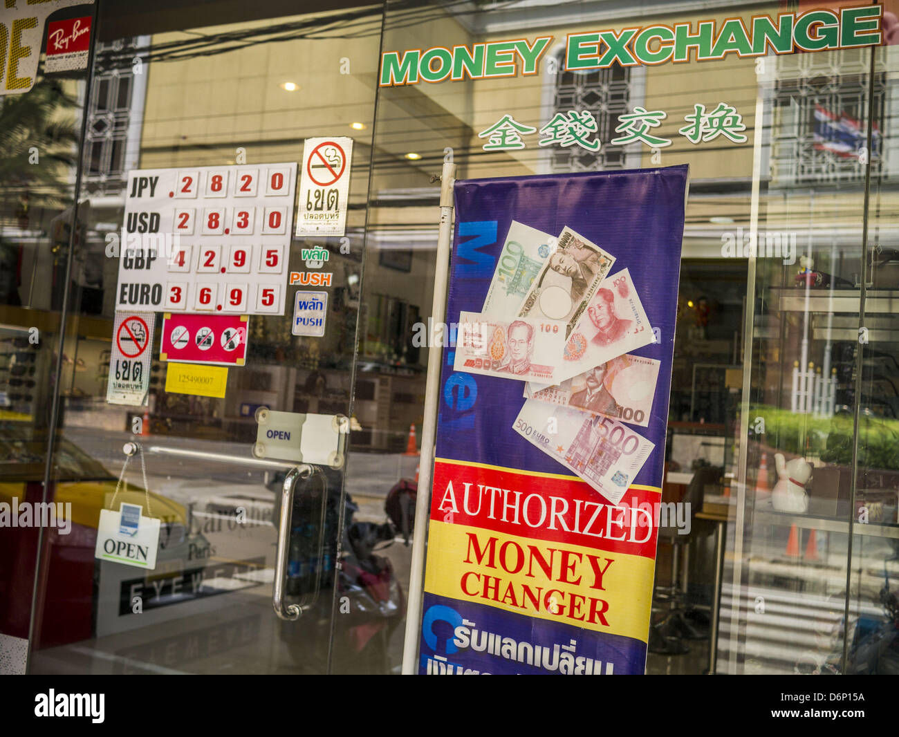 April 22, 2013 - Bangkok, Thailand - The exchange rate is posted in the window of a tourist curio shop that also operates as a currency exchange in Bangkok. The Thai Baht has gained markedly against the US Dollar, the Euro and Pound Sterling in recent months. On Monday, the Baht was trading at 28.57 Baht to 1 US Dollar on Apr. 22. The strengthening Baht means imported goods are cheaper in Thailand, but Thai exports cost more in other countries. It also means tourists and expats who live in Thailand have less money to spend as their currencies buy fewer Baht. The baht has risen 5 percent agains Stock Photo