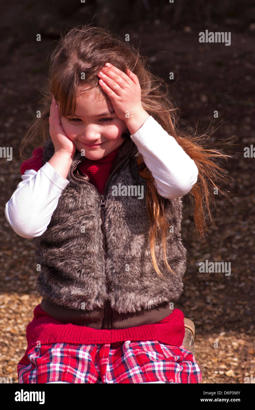 5 Year Old Girl With Long Brown Hair Dressed In Warm Clothing Outside Stock Photo