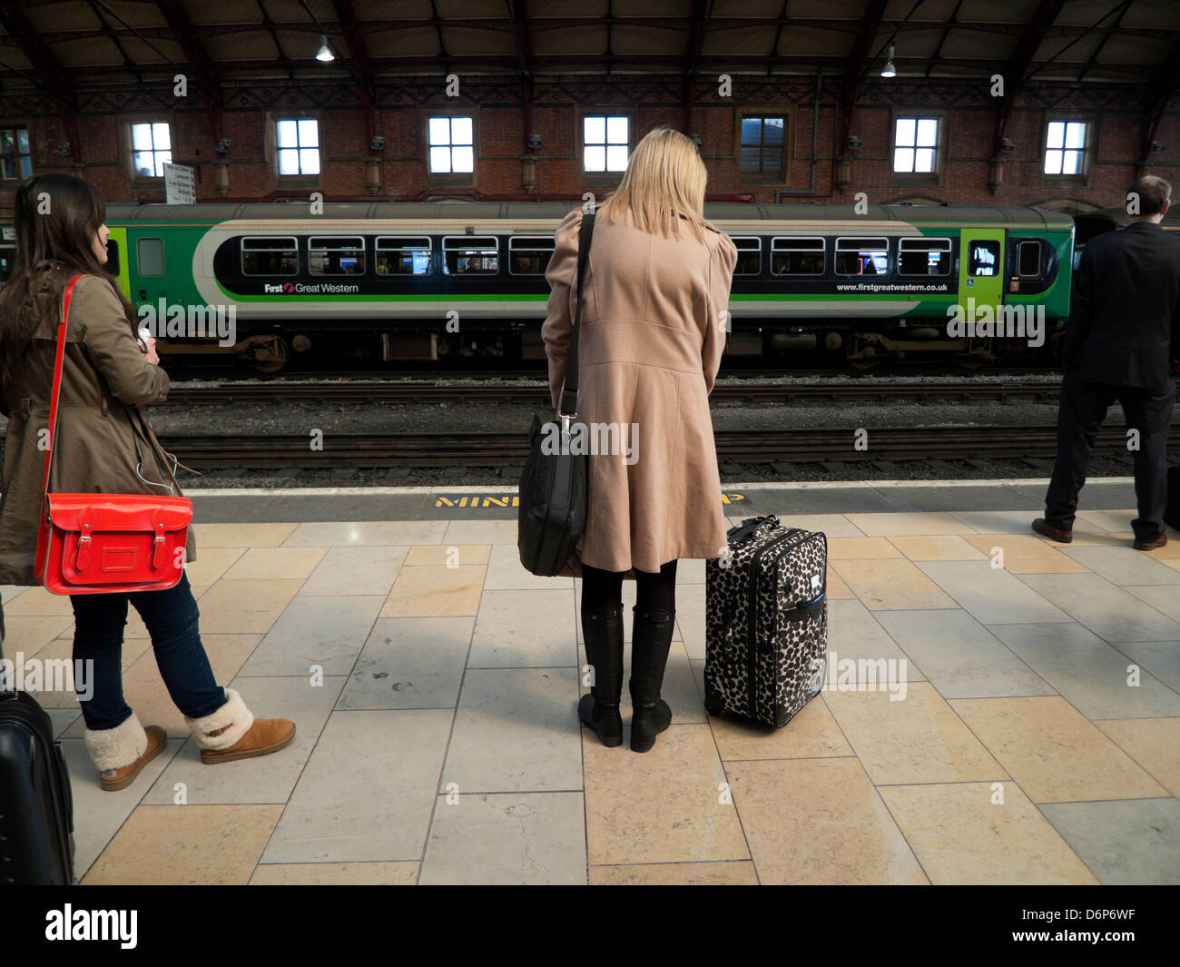 People with luggage waiting for a train on the platform at Bristol
