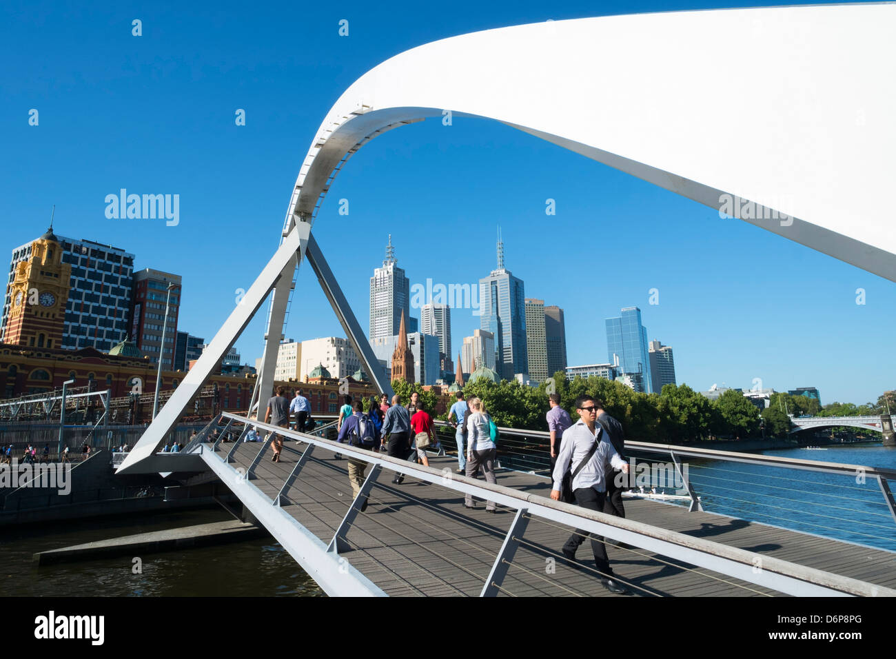 Pedestrians crossing Evan Walker Footbridge at Southbank  across Yarra River in central Melbourne Australia Stock Photo