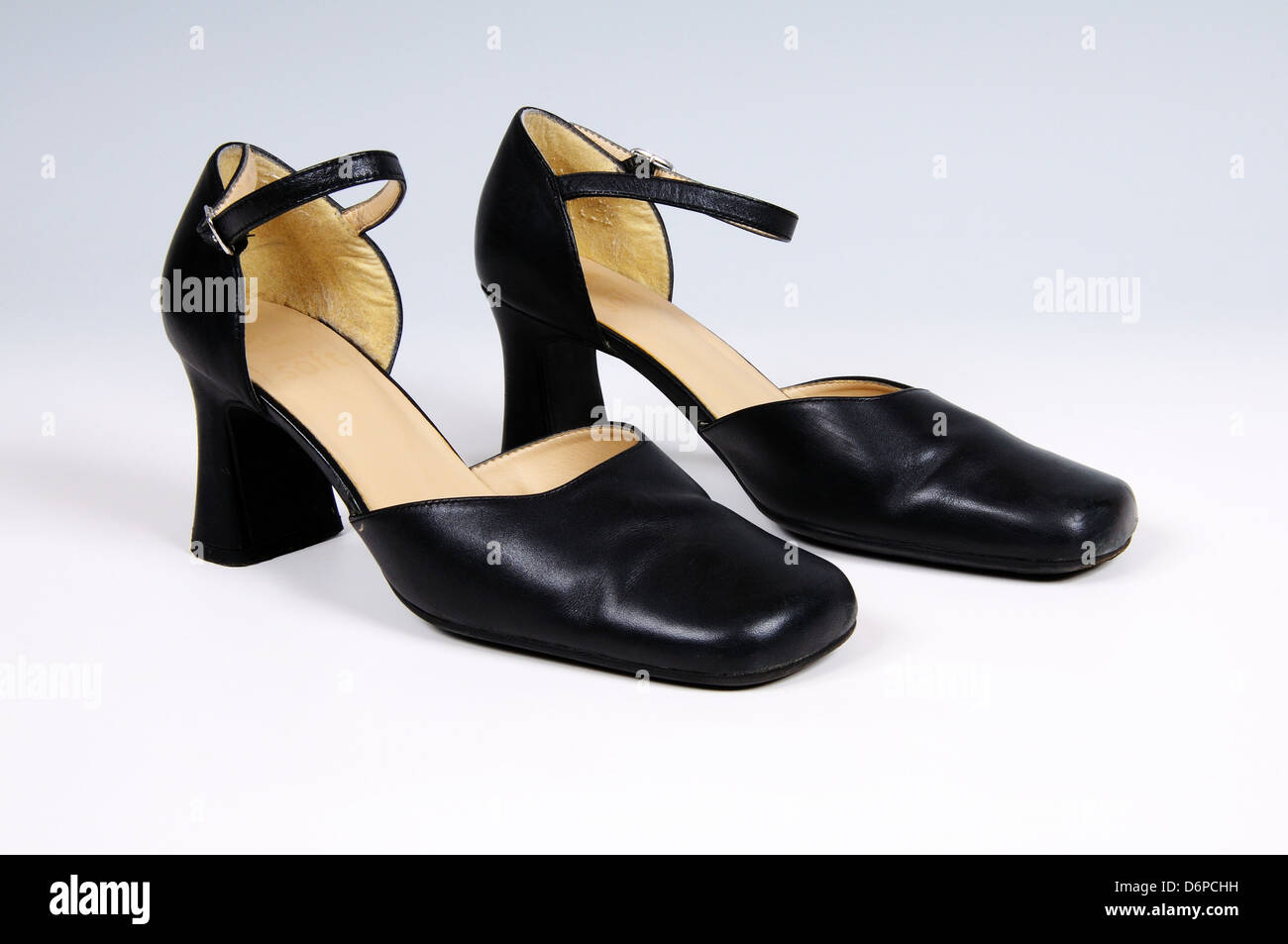 Pair of black leather womens shoes against a plain background. Stock Photo
