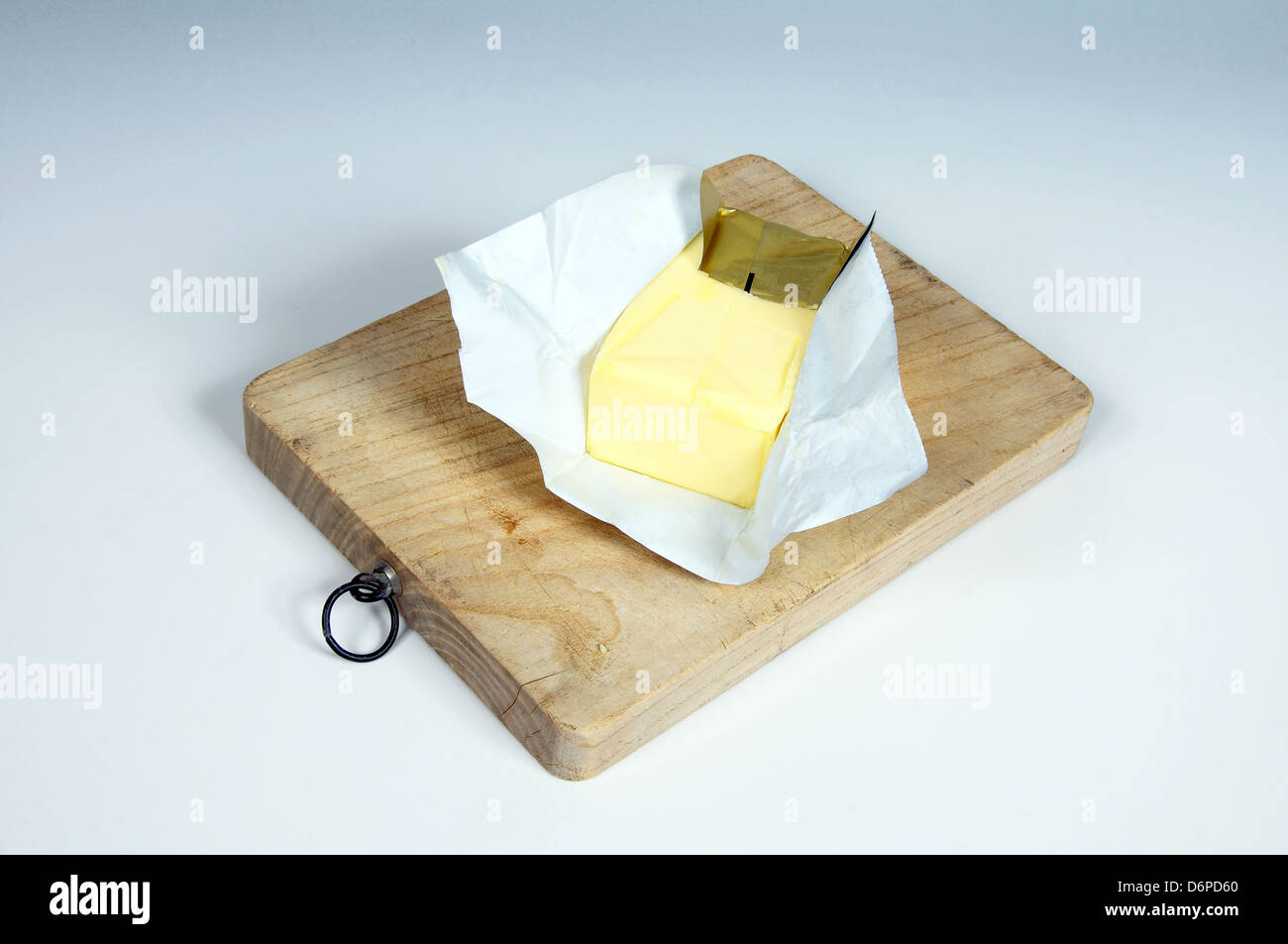 Block of English butter on a wooden chopping board. Stock Photo