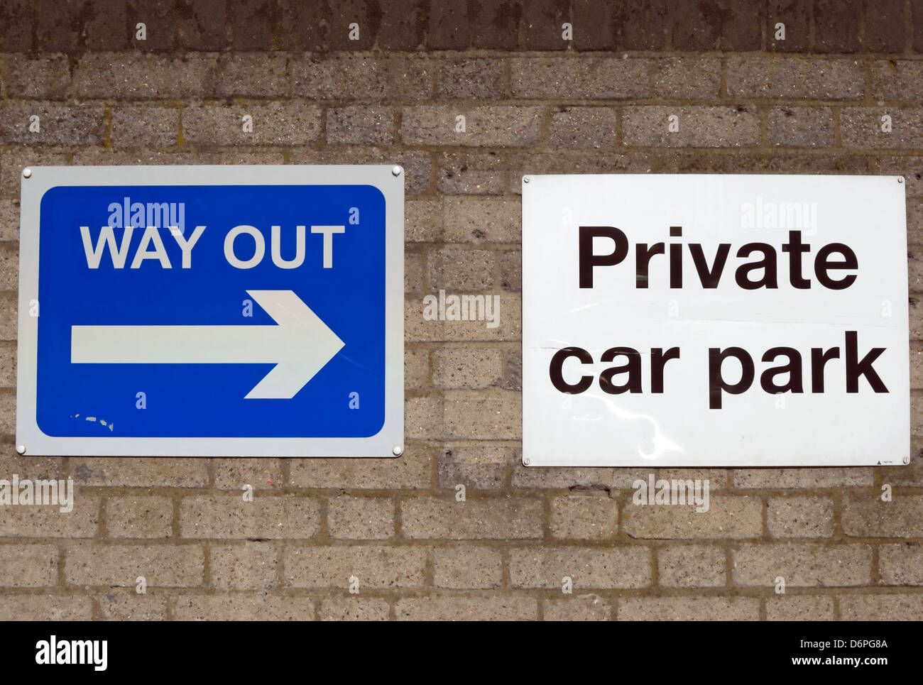signs for private car park and way out fixed to a wall, putney, southwest london, england Stock Photo