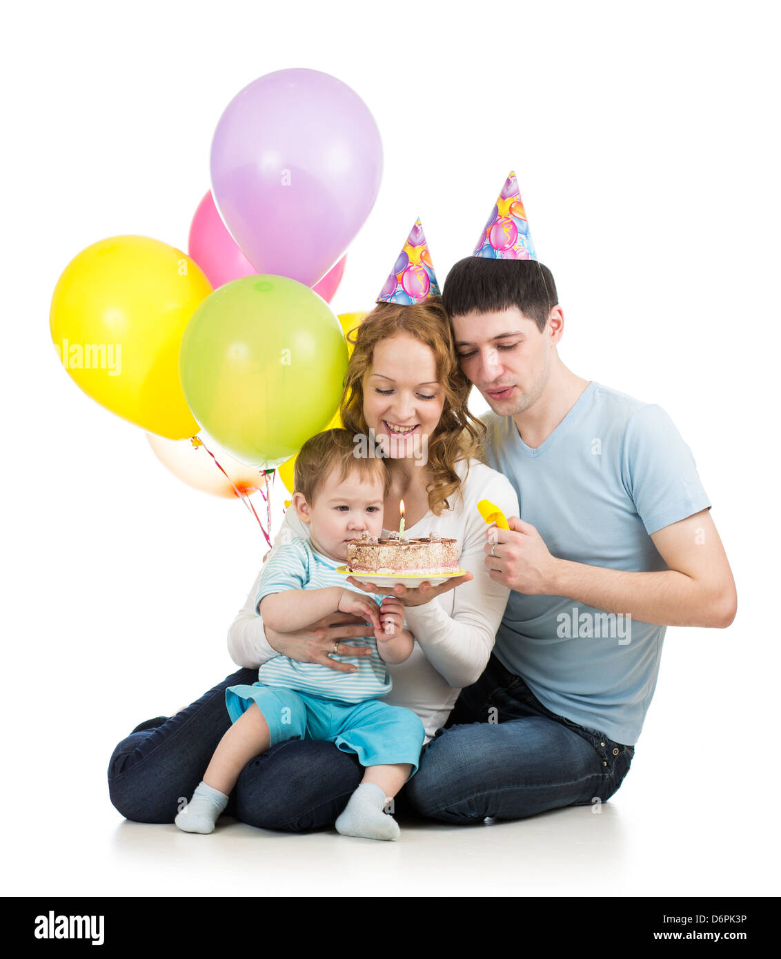 kid boy with parents looking at festive cake with candles Stock Photo