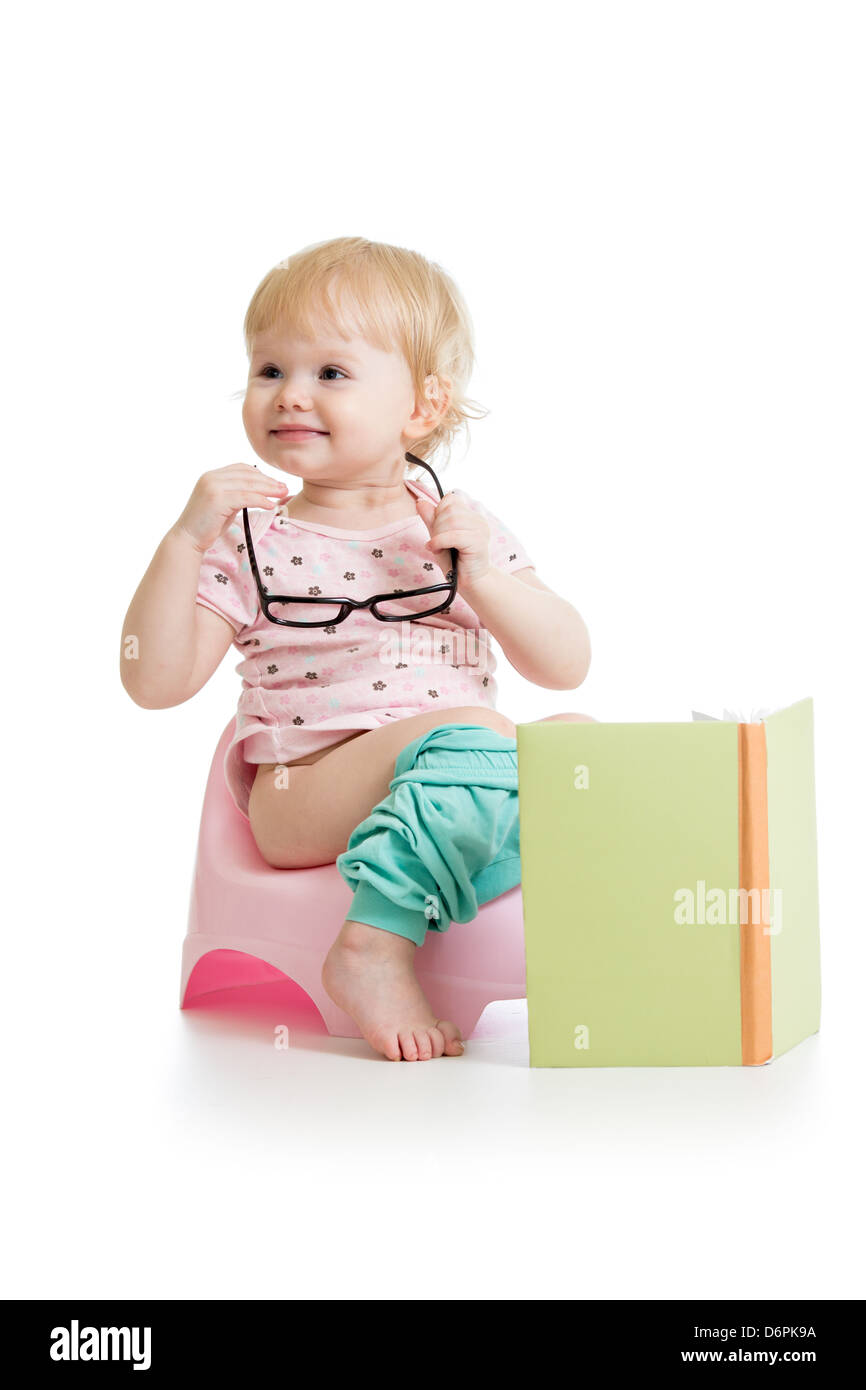 baby girl sitting on chamberpot with book Stock Photo - Alamy