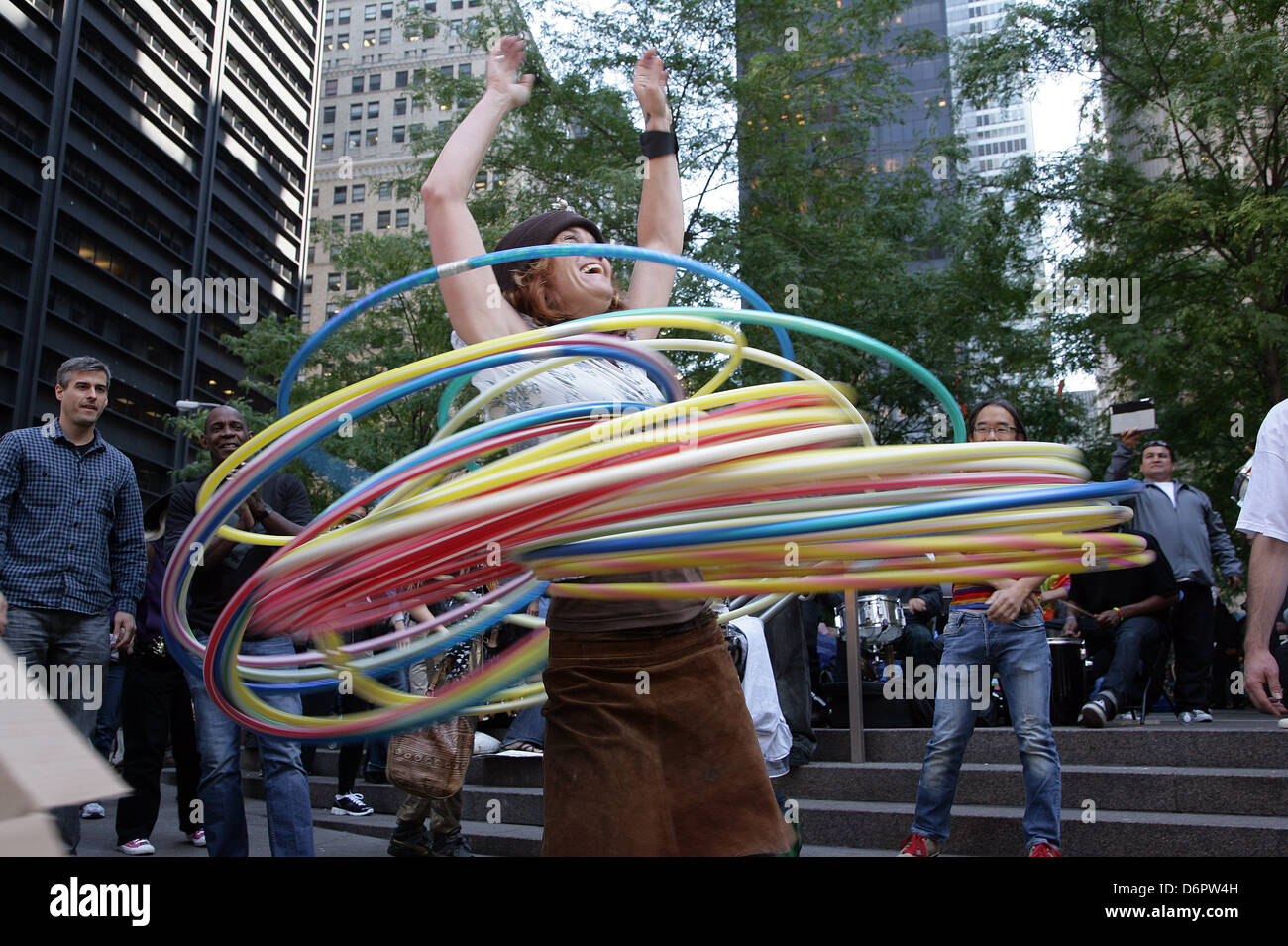A female protester entertains the passing crowds by hula hooping Occupy Wall Street is an ongoing series of demonstrations in Stock Photo