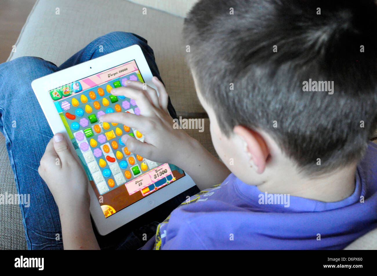 candy crush saga game ipad boy playing addicted winning concentrate game child Stock Photo