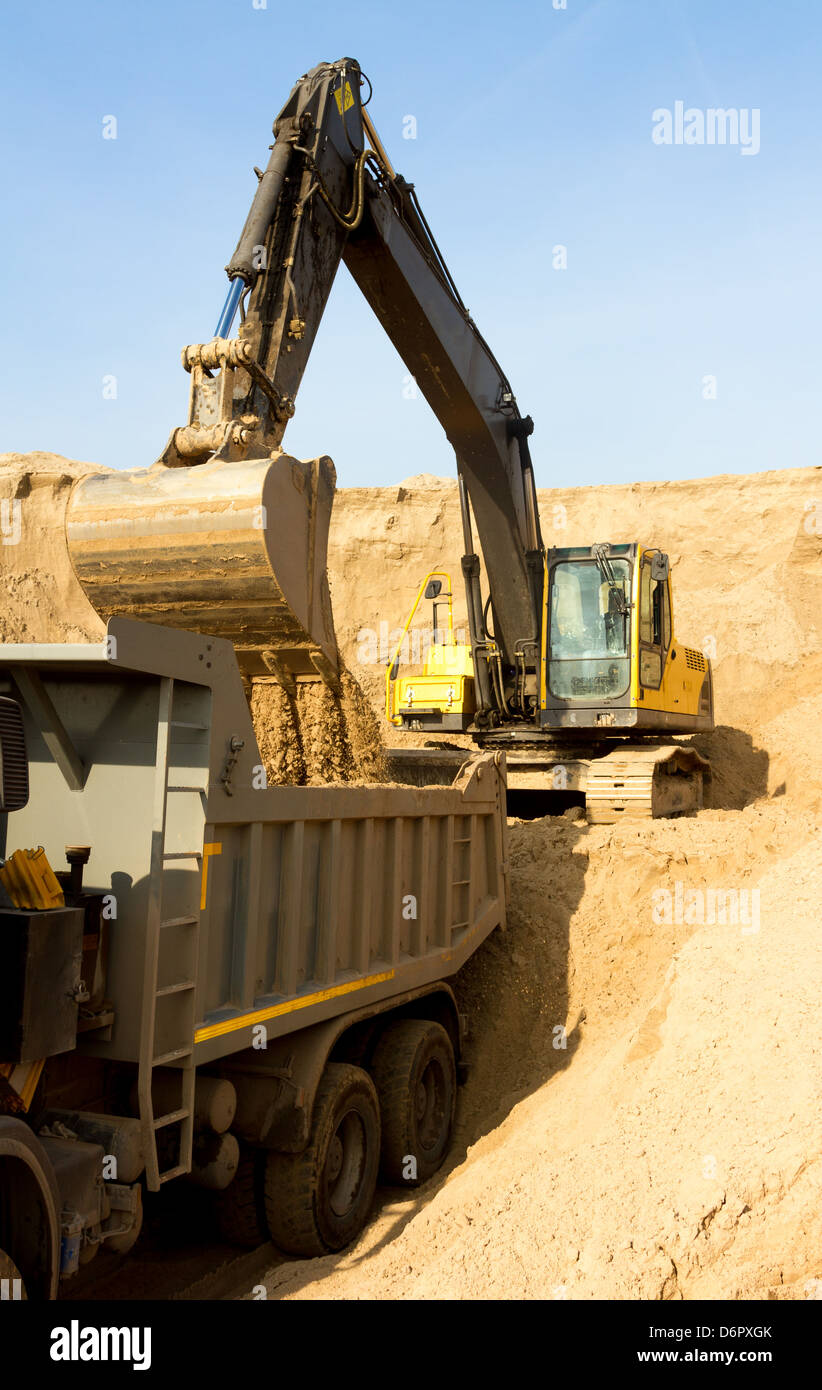 Excavator Loading Dumper Truck at Construction Site Stock Photo Alamy