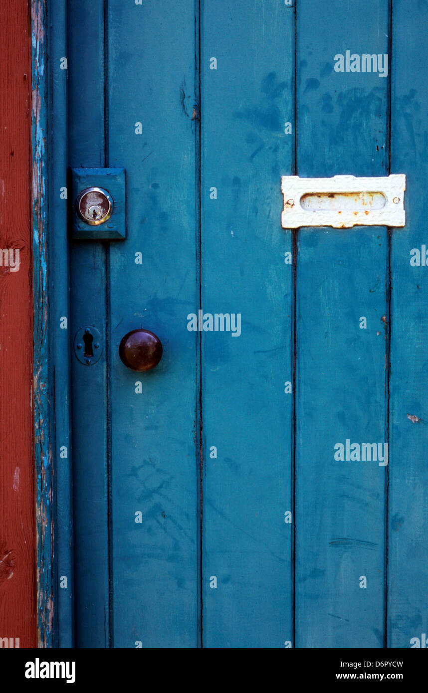 Blue door with fingermarks around letterbox, doorknob and key lock Stock Photo