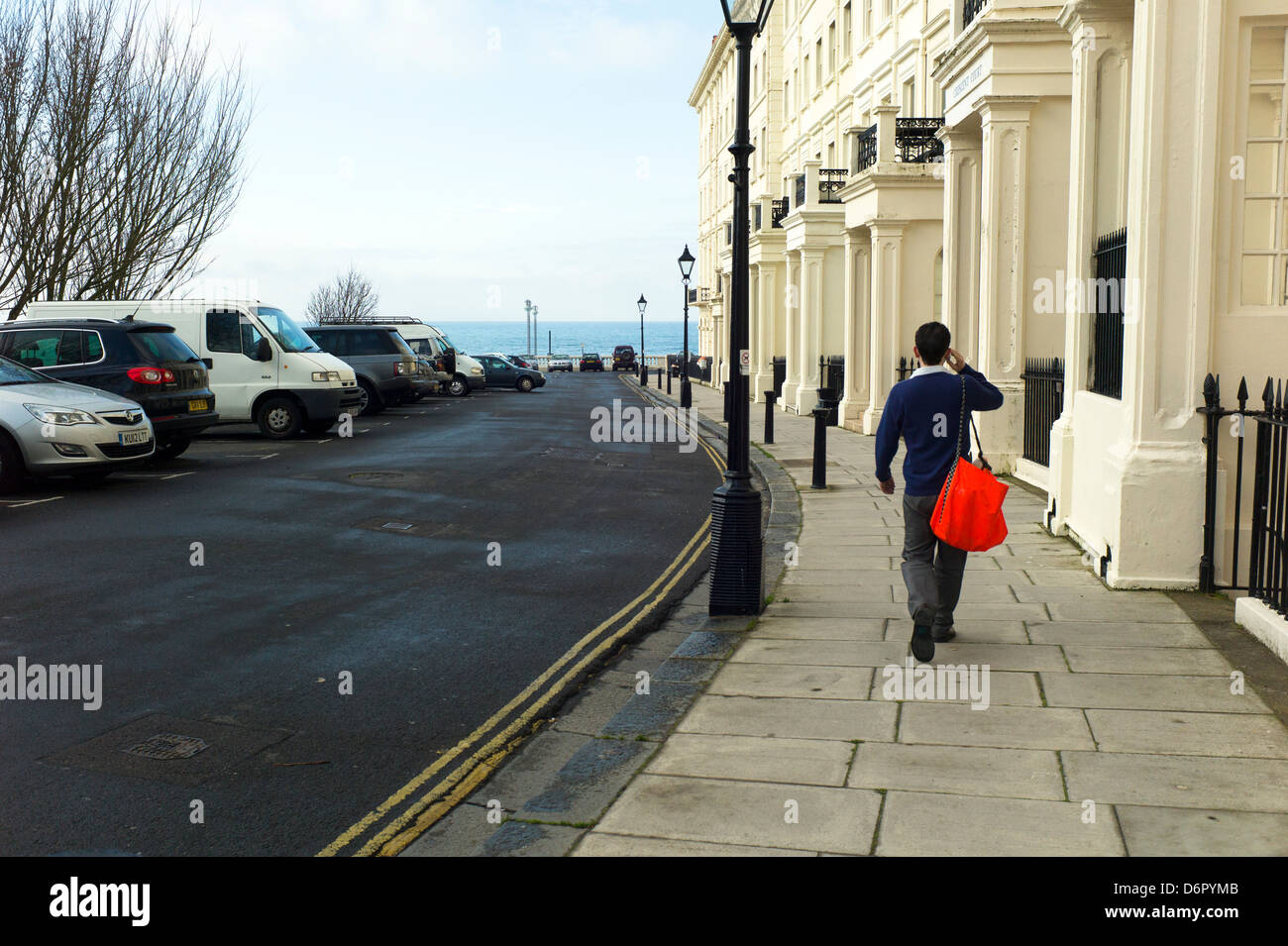 Newspaper delivery boy on phone,Palmeira Square, Hove Stock Photo