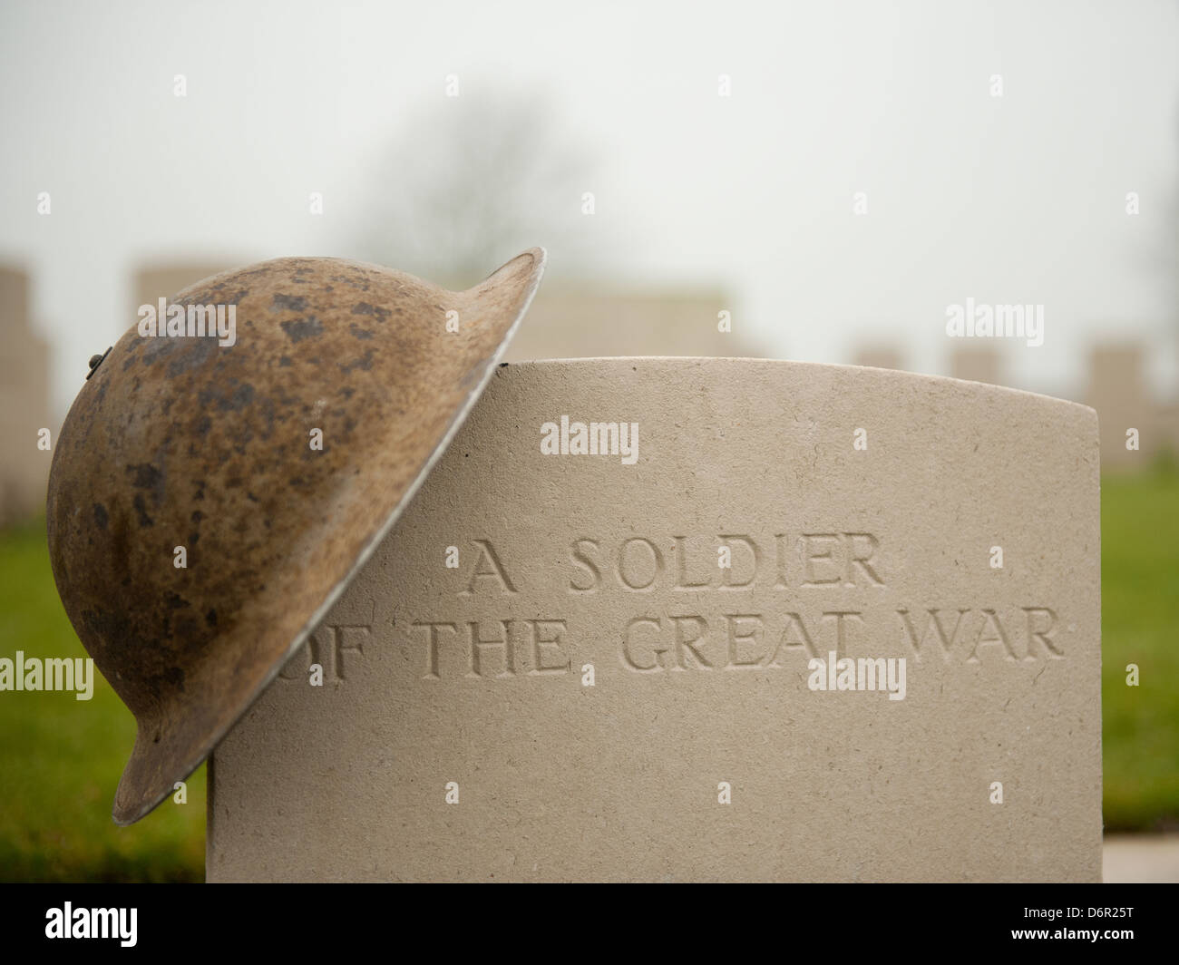 British military helmet resting upon the headstone of 'A SOLDIER OF THE GREAT WAR'. Stock Photo