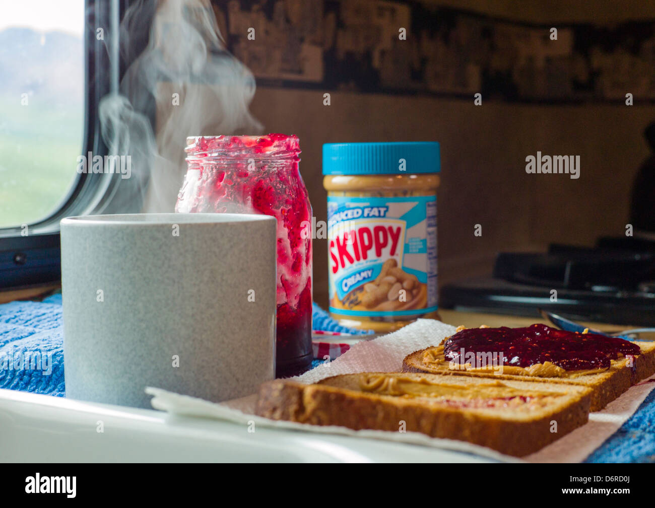 Peanut butter and jelly sandwich and hot coffee inside a camper, Denali