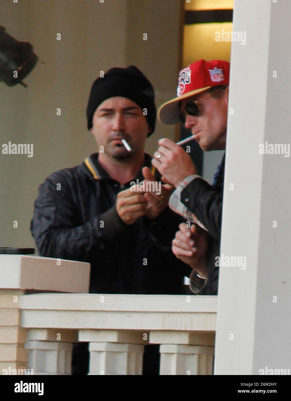 Eric Dane lighting a cigarette on the balcony while leaving Barneys New  York store in Beverly Hills wearing a San Francisco Stock Photo