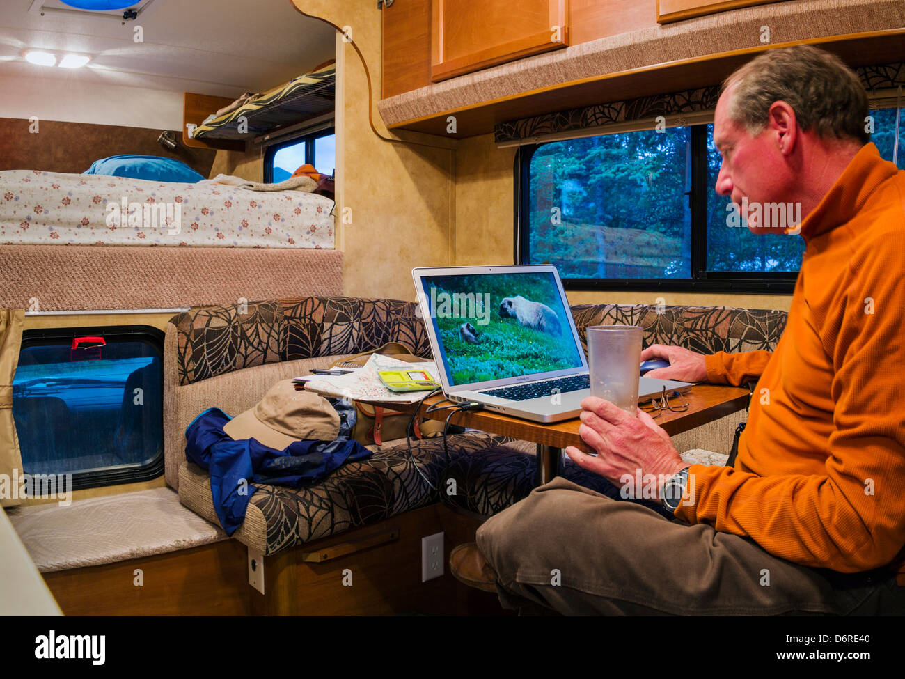 Professional photographer H. Mark Weidman editing digital photographs on a laptop computer inside a camper Denali National Park Stock Photo