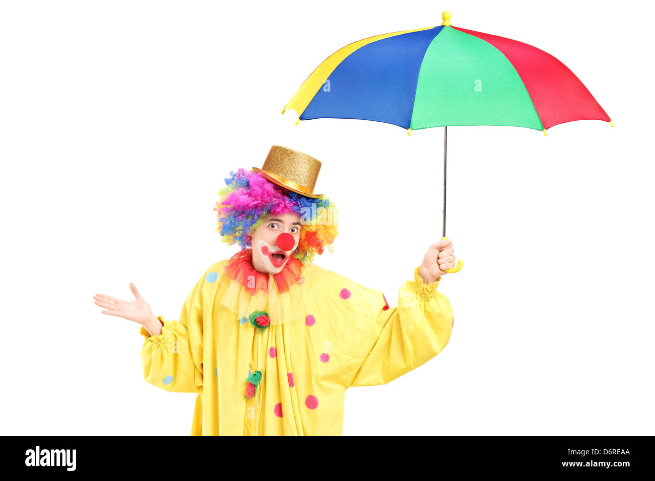 A cheerful clown holding a colorful umbrella isolated on white ...