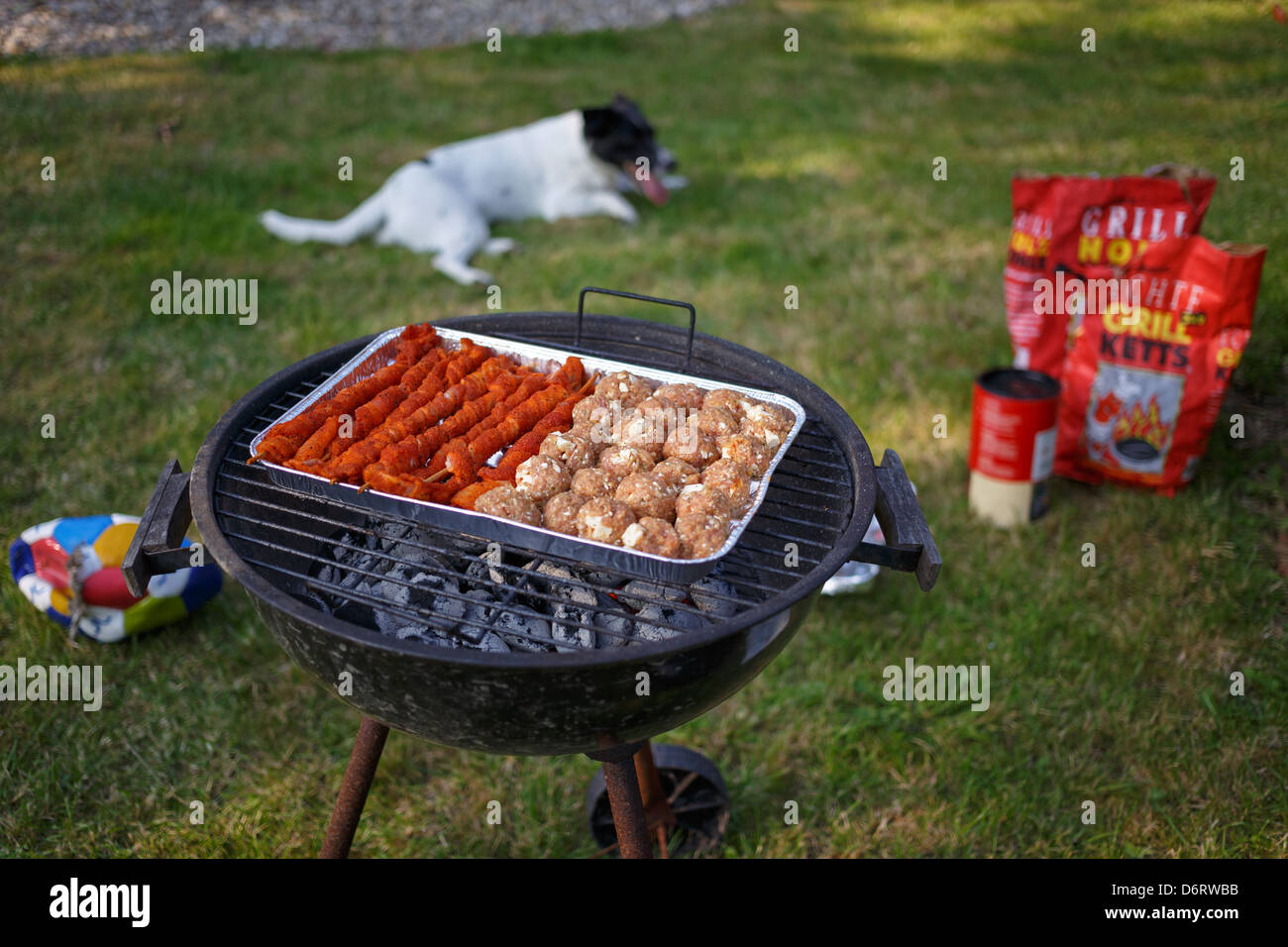 Emden, Germany, on a charcoal grill in a foil dish are meat and Hackbaellchen torches Stock Photo
