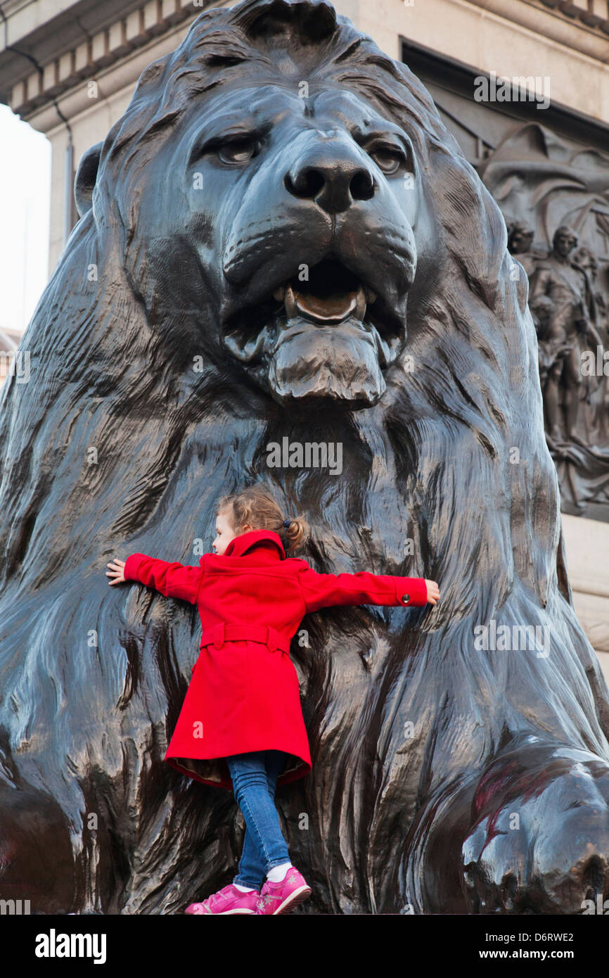 UK, London, Trafalgar Square, Child Hugging Lion Statue Stock Photo