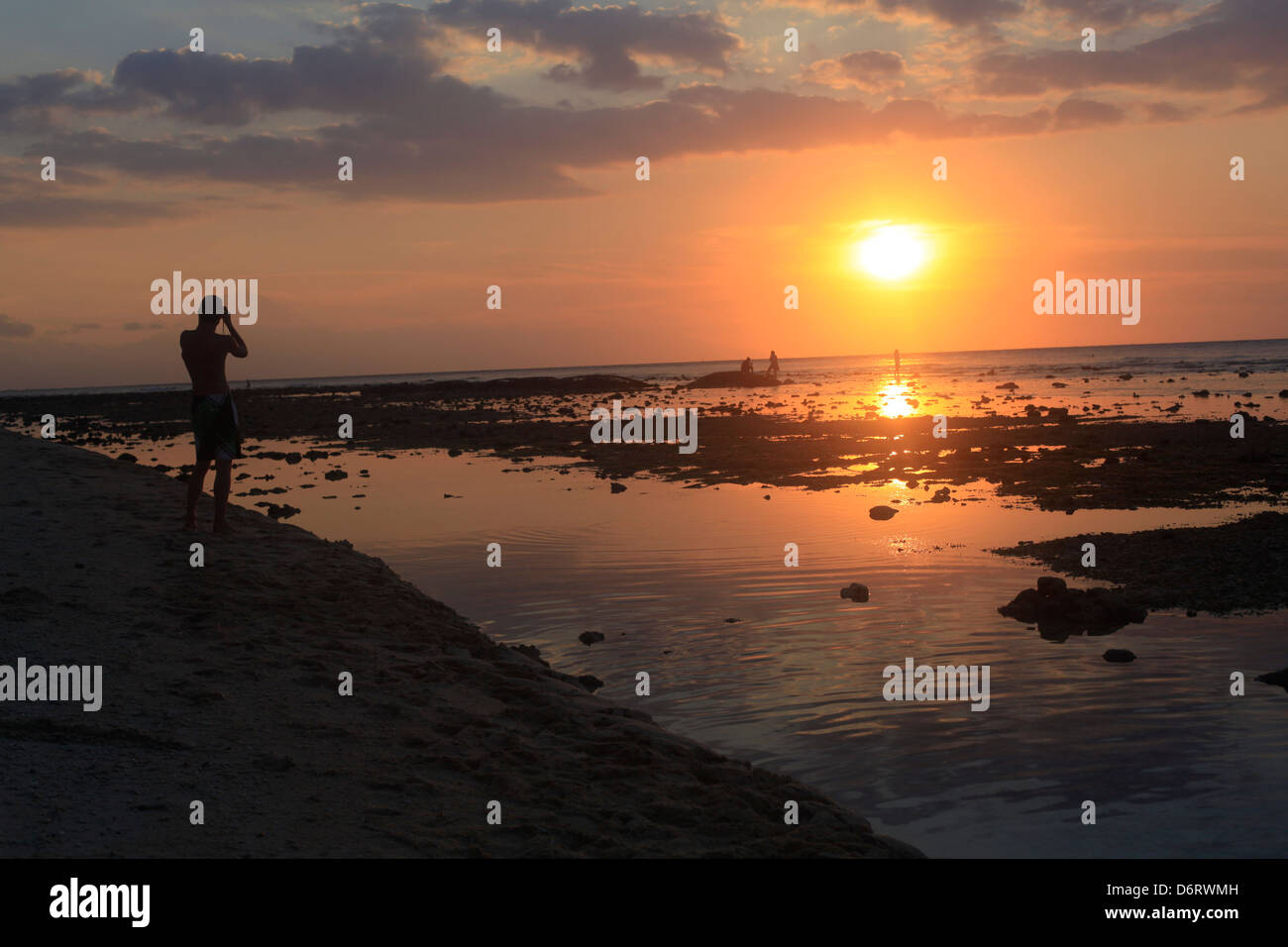 tourists enjoy a spectacular sunset on the island of Gili Trawangan Lombok Indonesia. Stock Photo