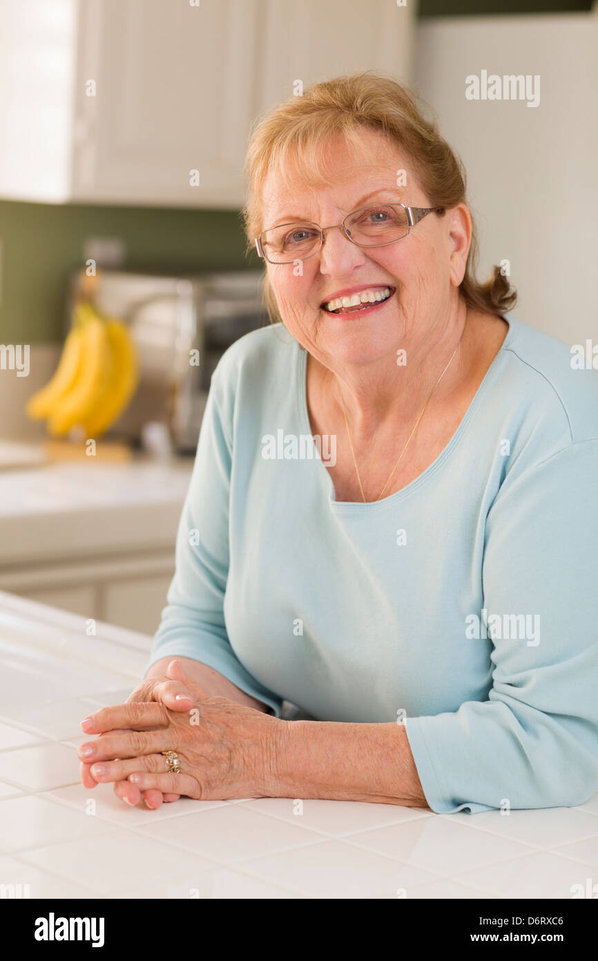 Portrait of a Beautiful Smiling Senior Adult Woman in Kitchen. Stock Photo