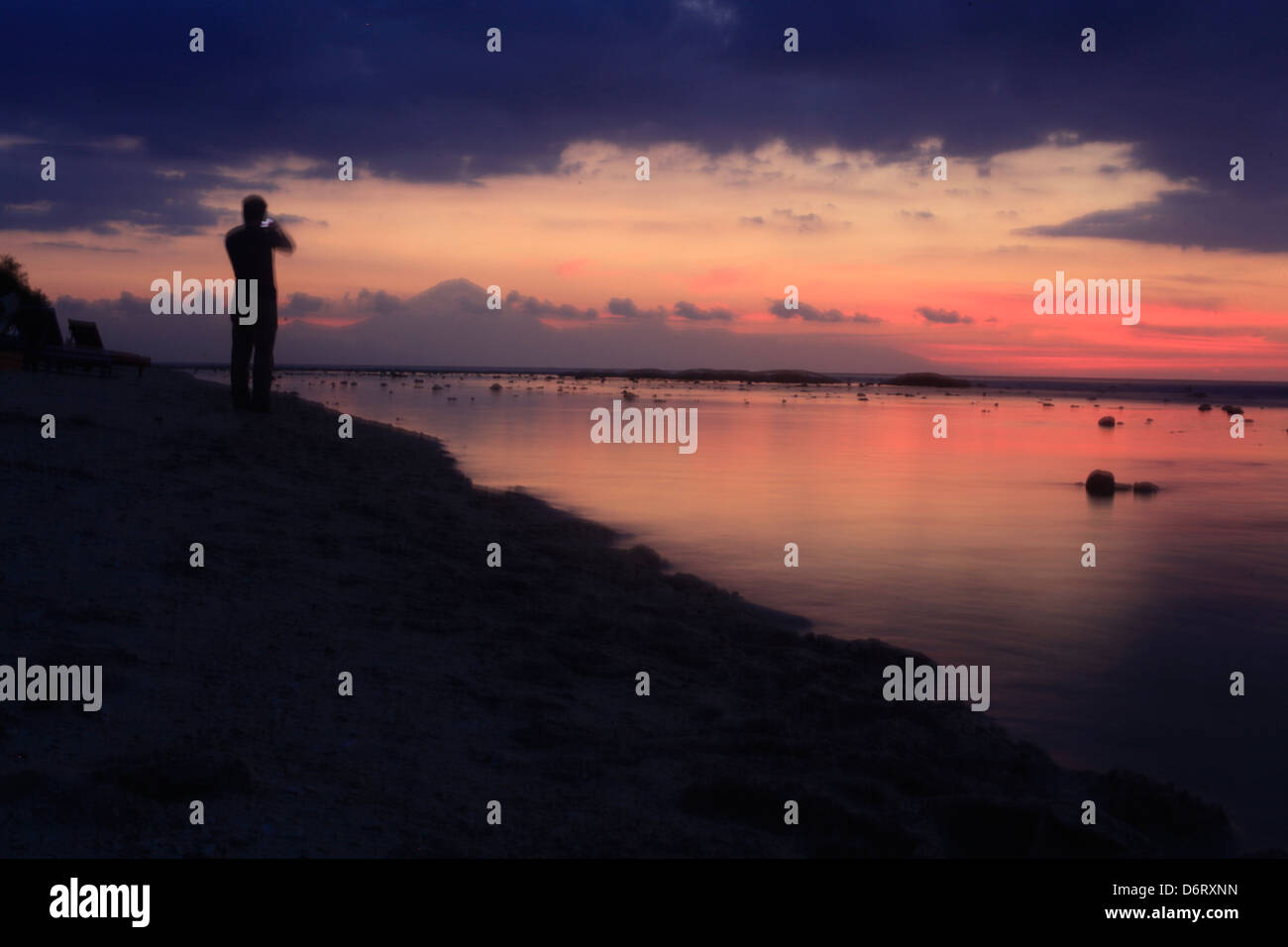 tourists enjoy a spectacular sunset on the island of Gili Trawangan Lombok Indonesia. Stock Photo