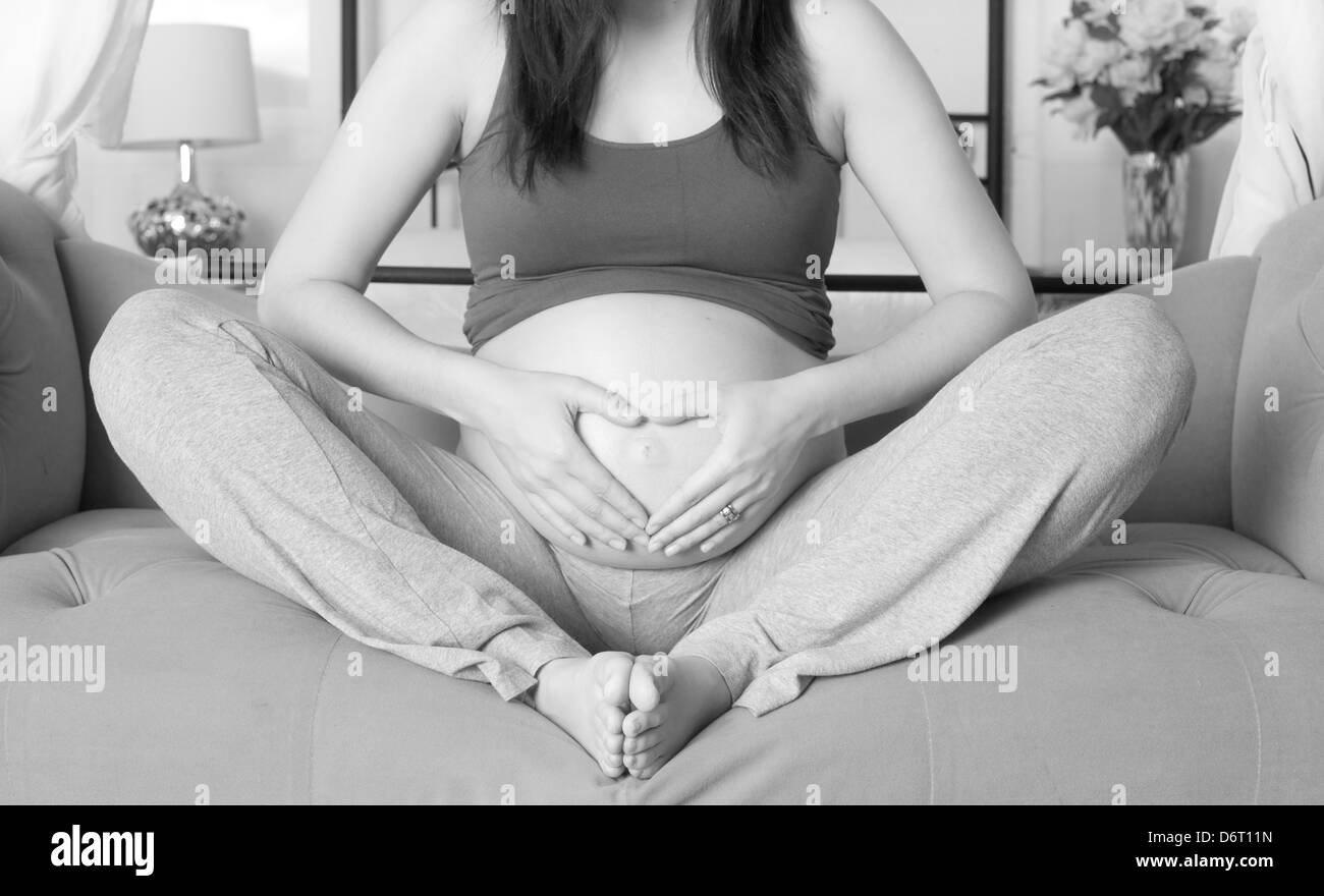 Woman shows her belly while pregnant with little girl Stock Photo