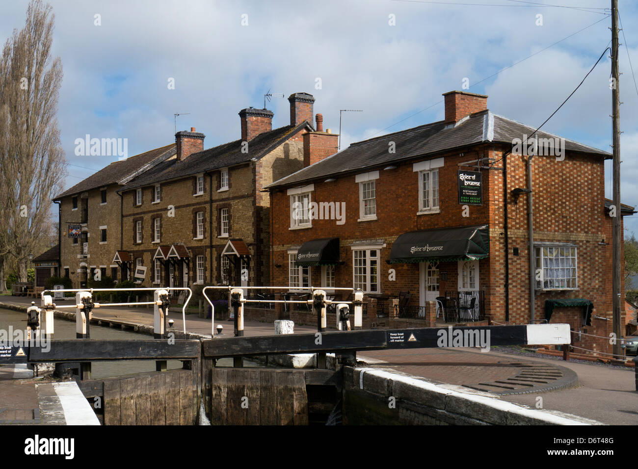 STOKE BRUERNE, NORTHAMPTONSHIRE, UK - APRIL 18, 2013:   The Lock aon the Grand Union Canal with canalside houses Stock Photo