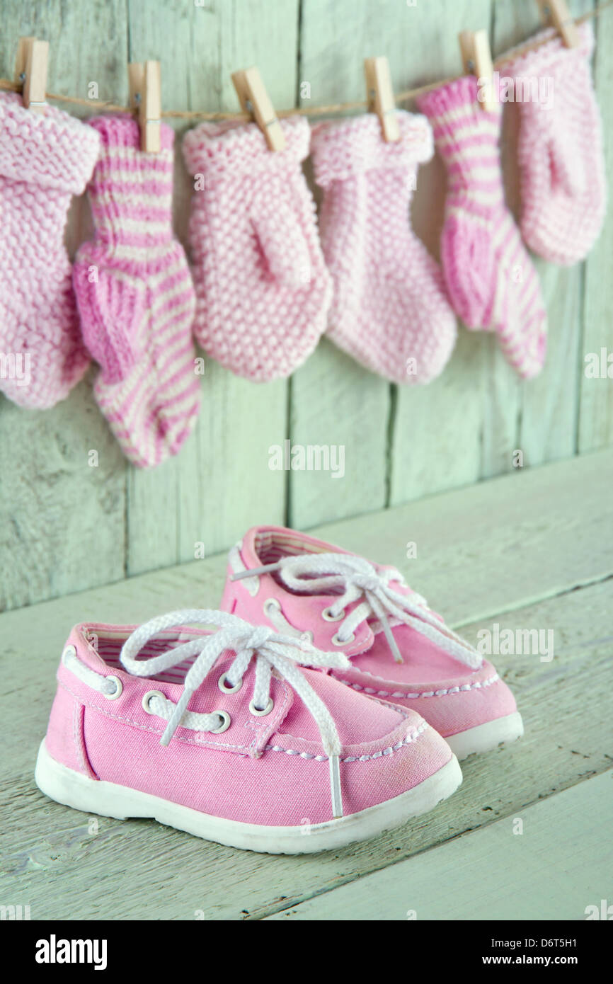 Pink toddler shoes on wooden light green vintage background Stock Photo