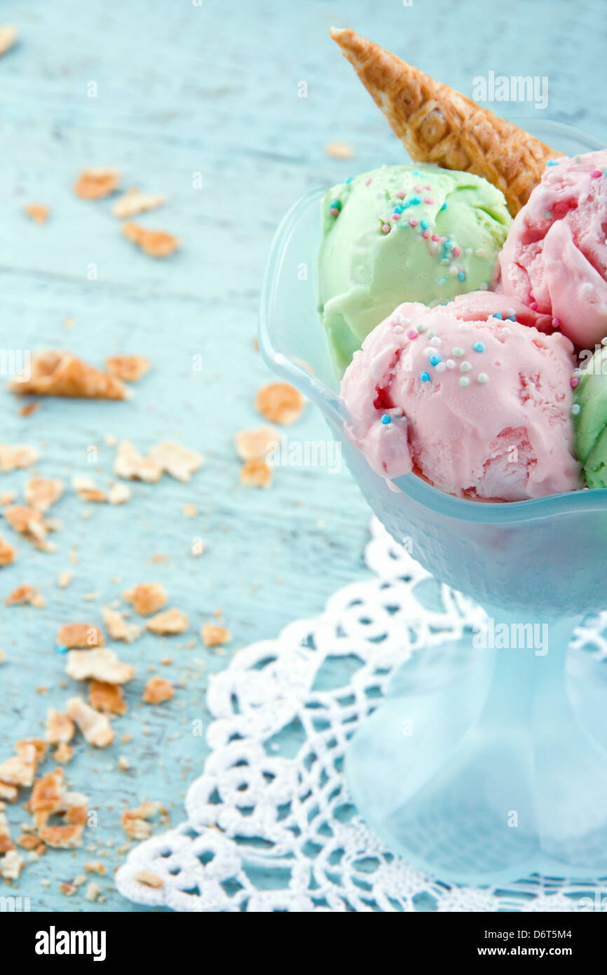 Bowl of pink and green ice cream with sprikles on vintage wooden shabby chic background Stock Photo