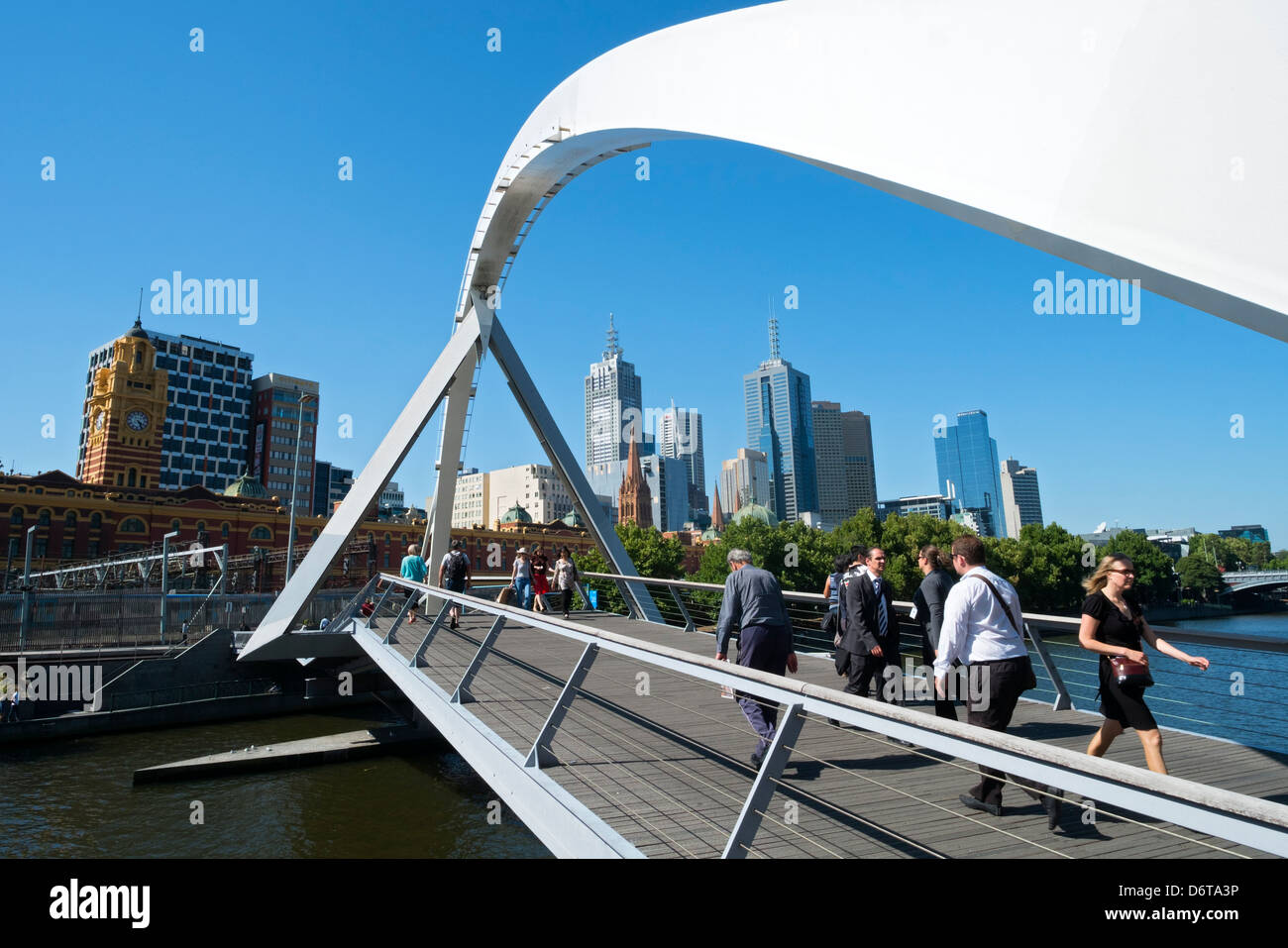 Pedestrians crossing Evan Walker Footbridge at Southbank  across Yarra River in central Melbourne Australia Stock Photo