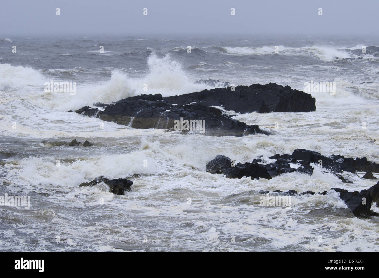 Waves crashing against rocks in stormy weather on east coast, Macduff, Aberdeenshire, Scotland, August Stock Photo