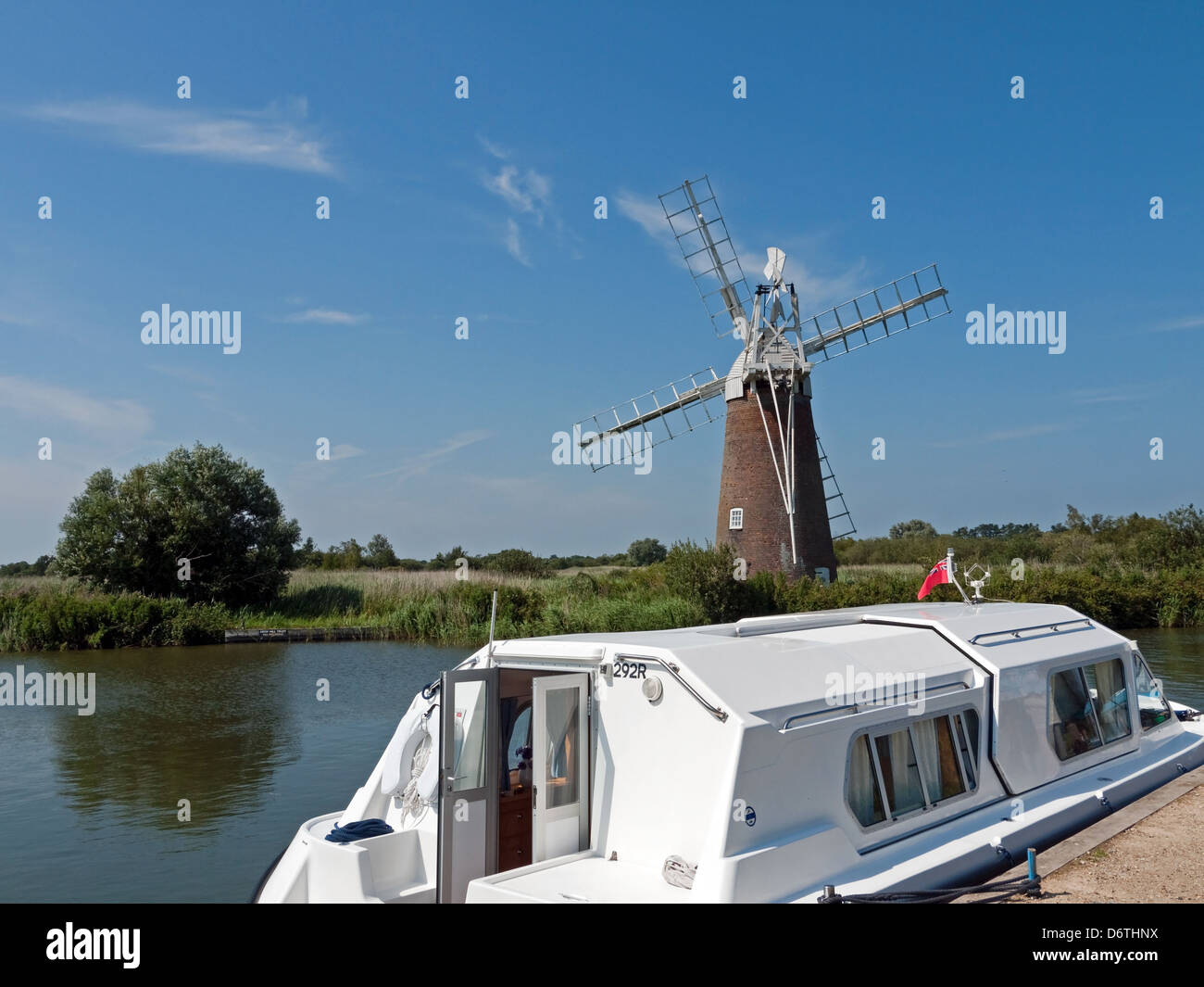 Holiday Leisure Boat beside Turf Fen Mill on the River Ant, How Hill, Norfolk Broads, England Stock Photo