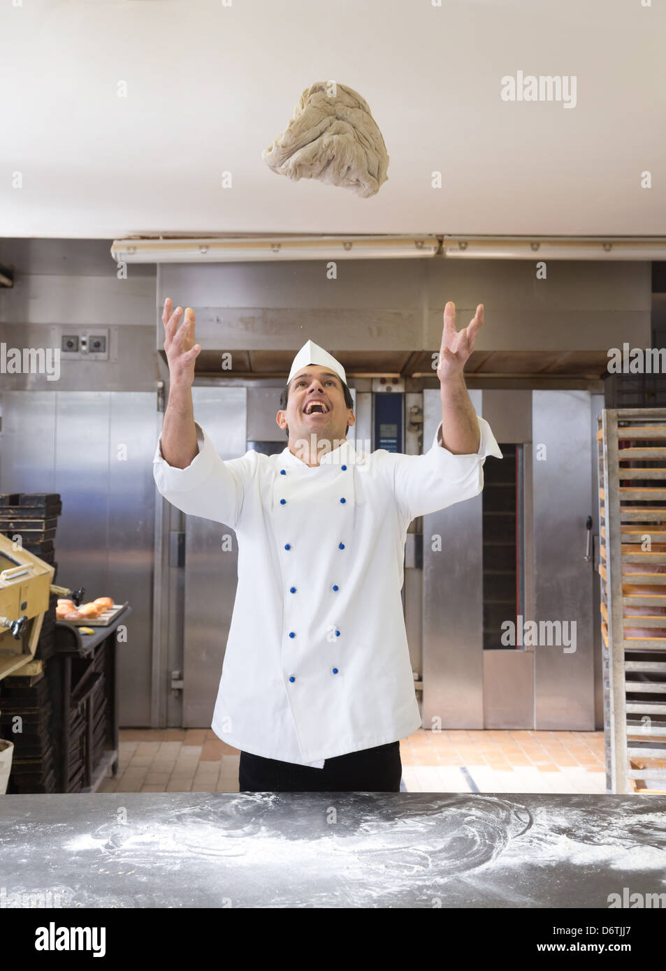Baker throwing bread dough in bakery Stock Photo Alamy