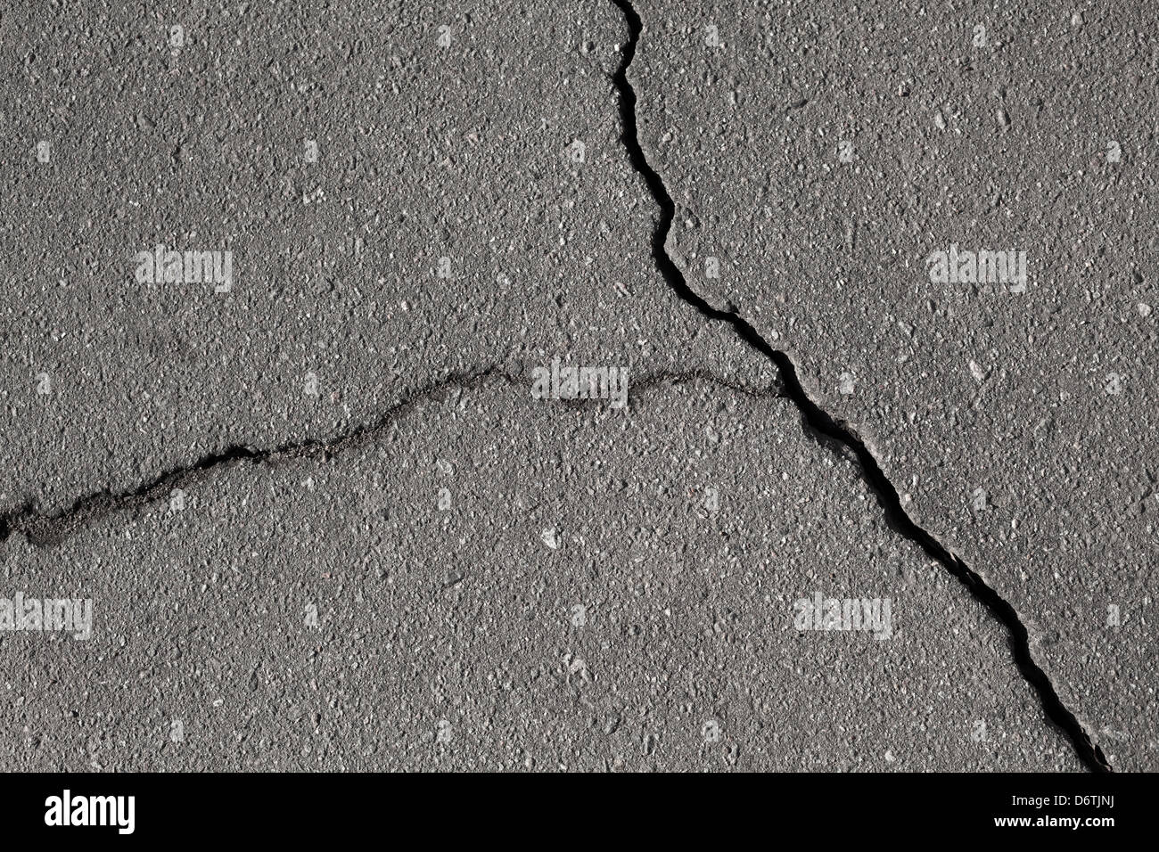 Closeup texture of damaged asphalt road surface with cracks Stock Photo