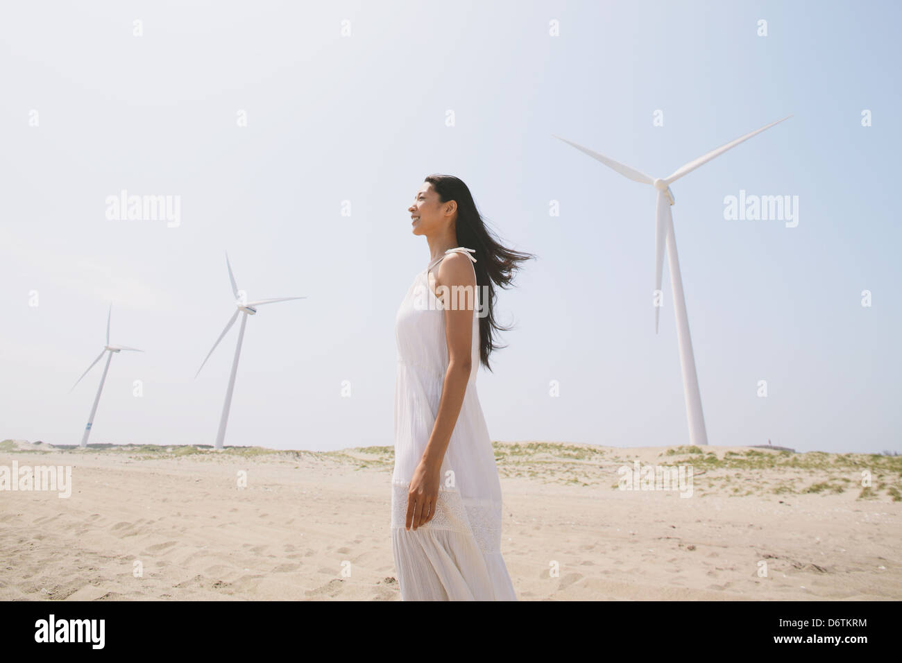 Woman in a white dress on the beach smiling away Stock Photo - Alamy