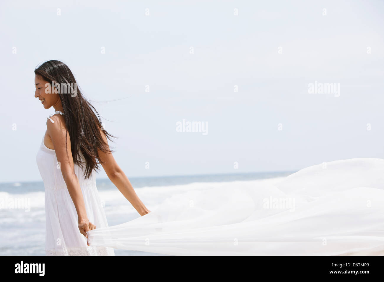 Woman in a white dress with white cloth on the beach Stock Photo - Alamy