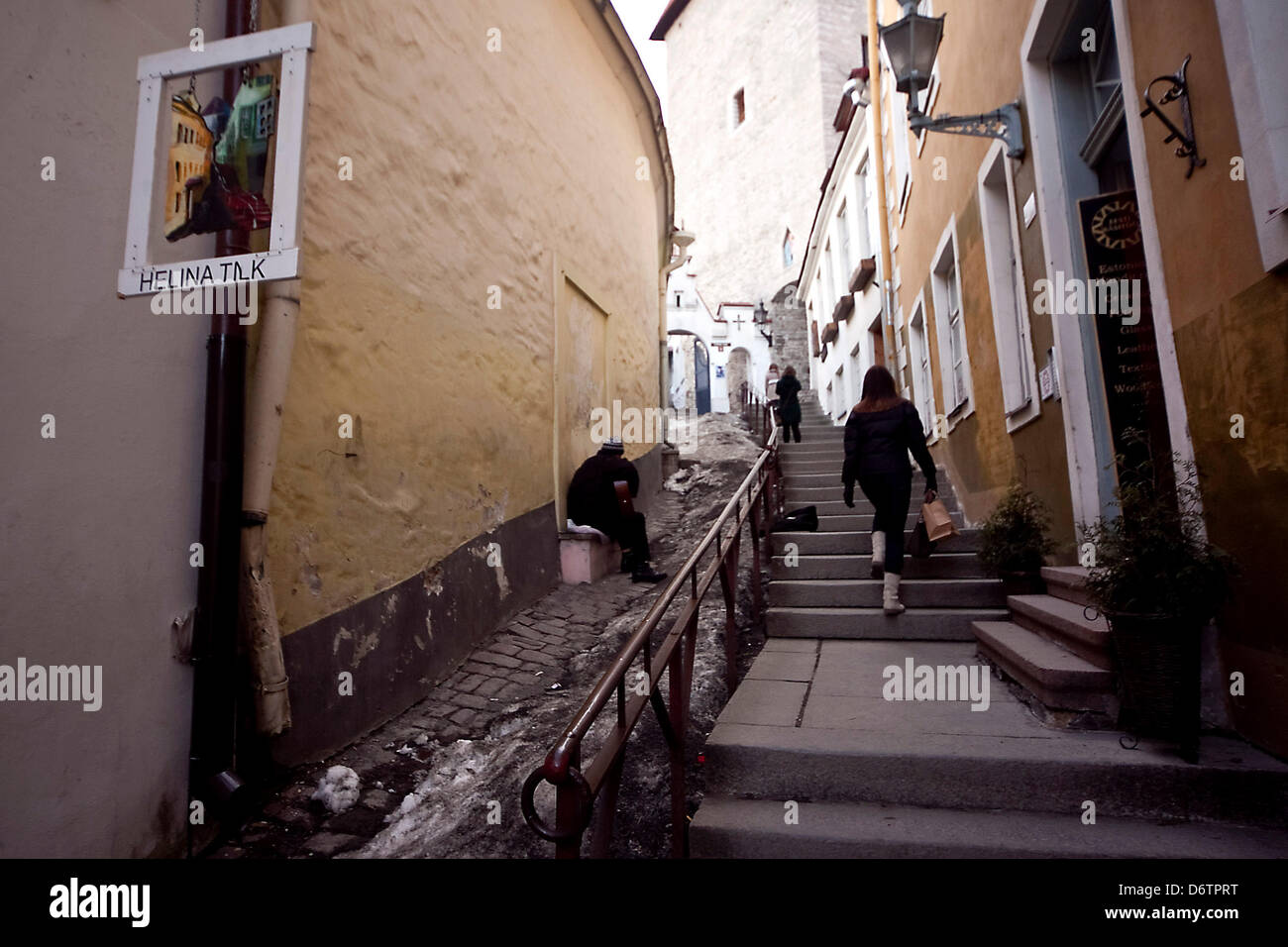 Insight into a narrow street with cobblestones and old houses at dusk in the Estonian capital Tallinn. Stock Photo