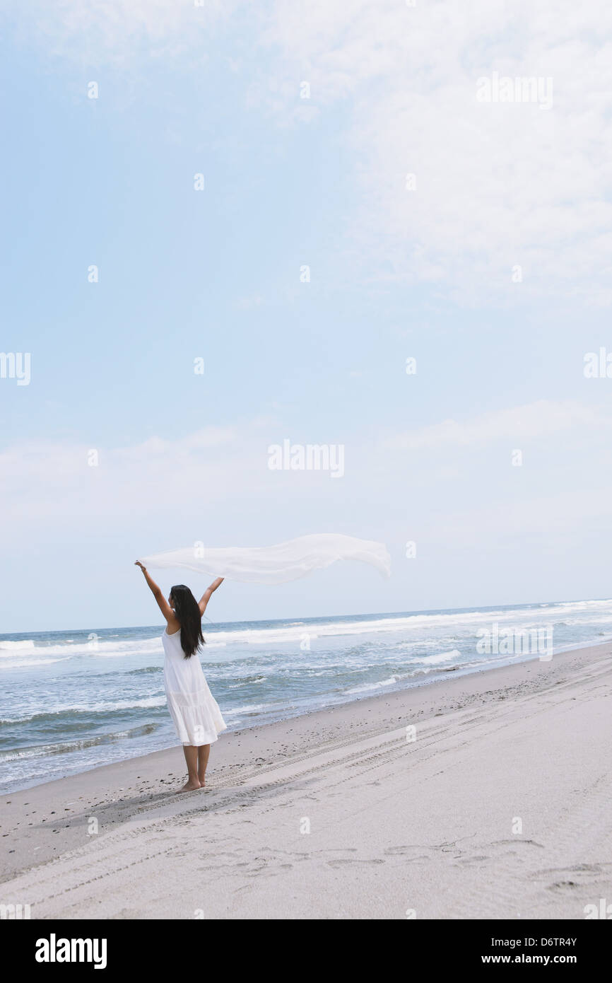 Woman in a white dress with white cloth on the beach Stock Photo - Alamy