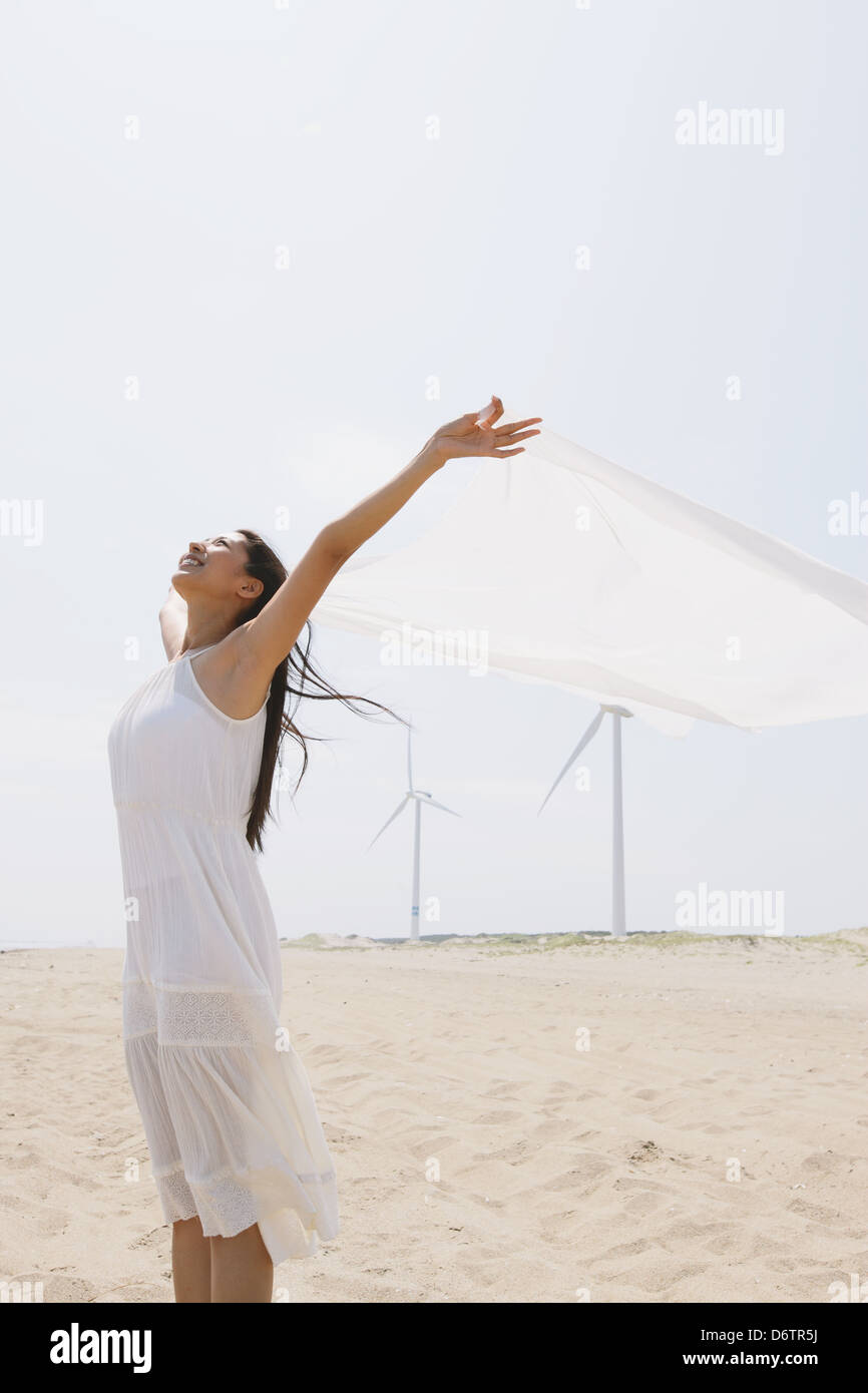 Woman in a white dress with white cloth on the beach Stock Photo - Alamy