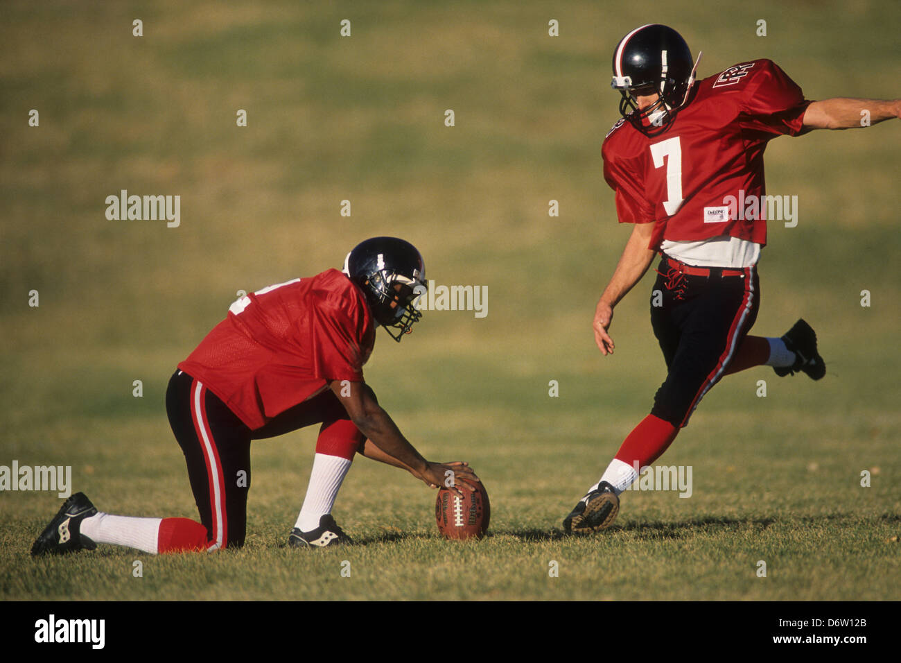 Football place kicker and holder in action., Stock Photo