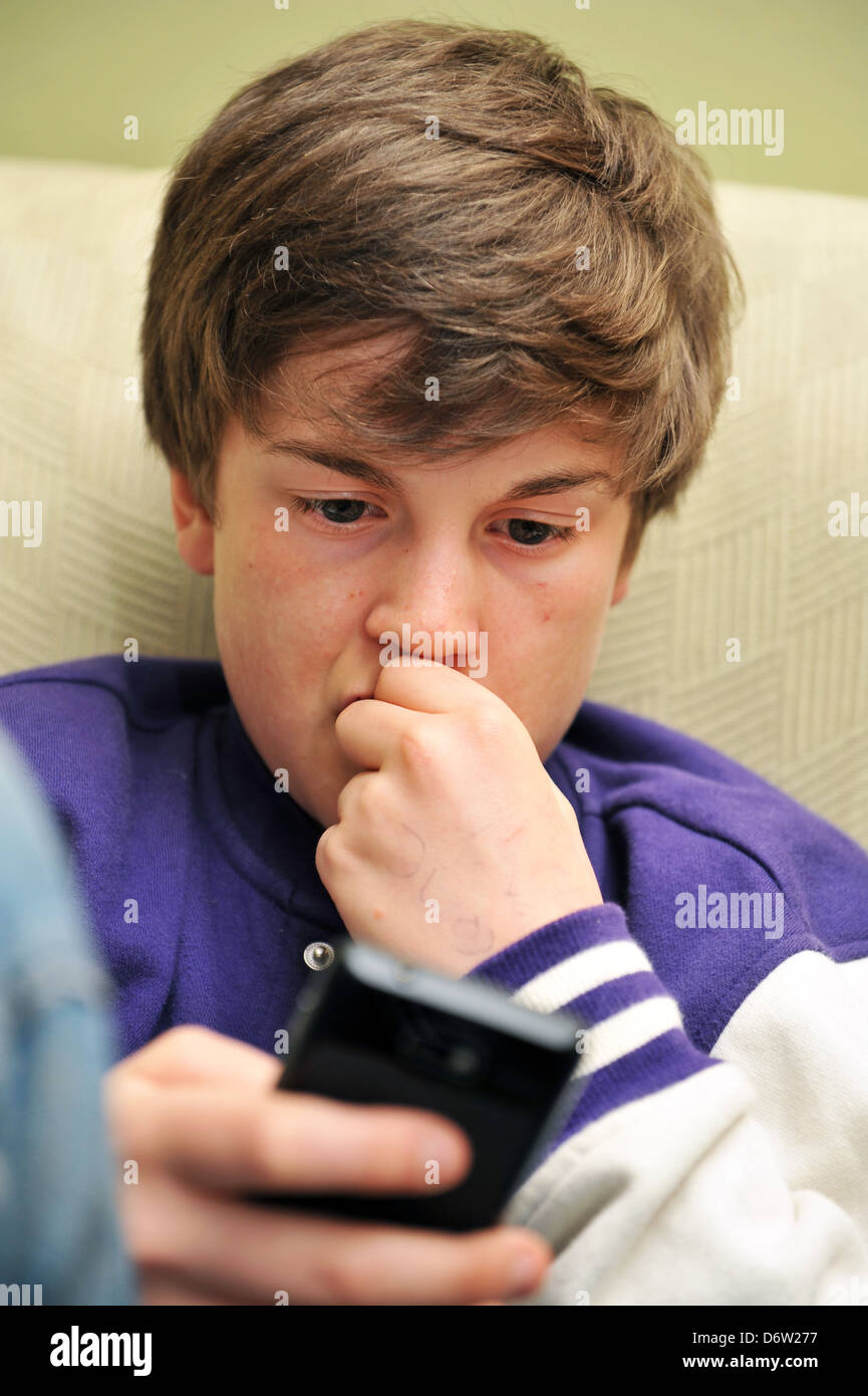 Twelve year old boy uses his mobile phone  for social networking Stock Photo