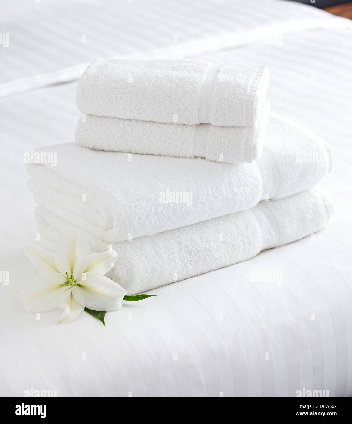 stack white fresh towels white bed Lily Stock Photo