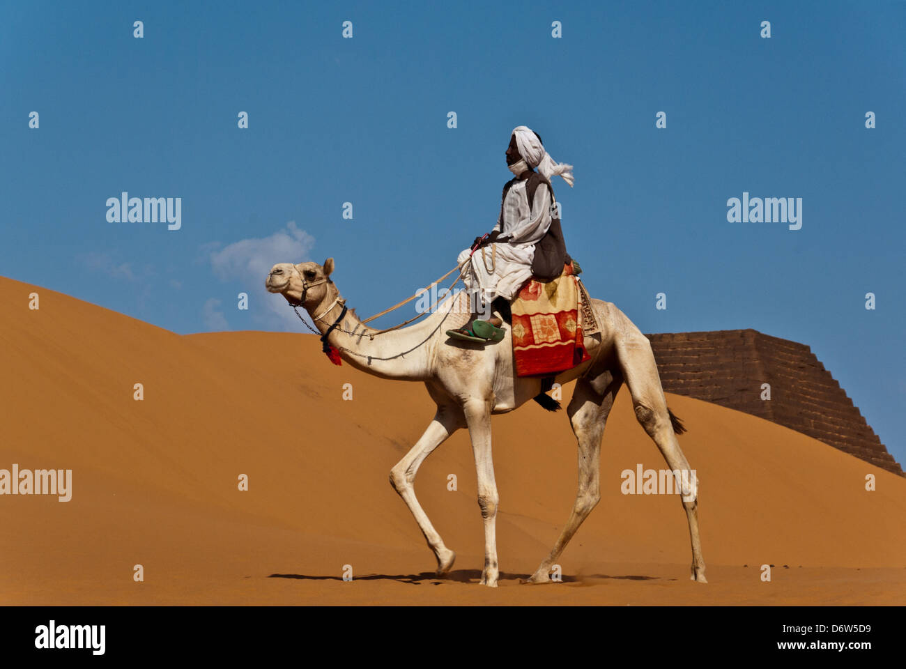 Camel rider waiting for tourists at the Pyramids of Meroe, northern Sudan Stock Photo