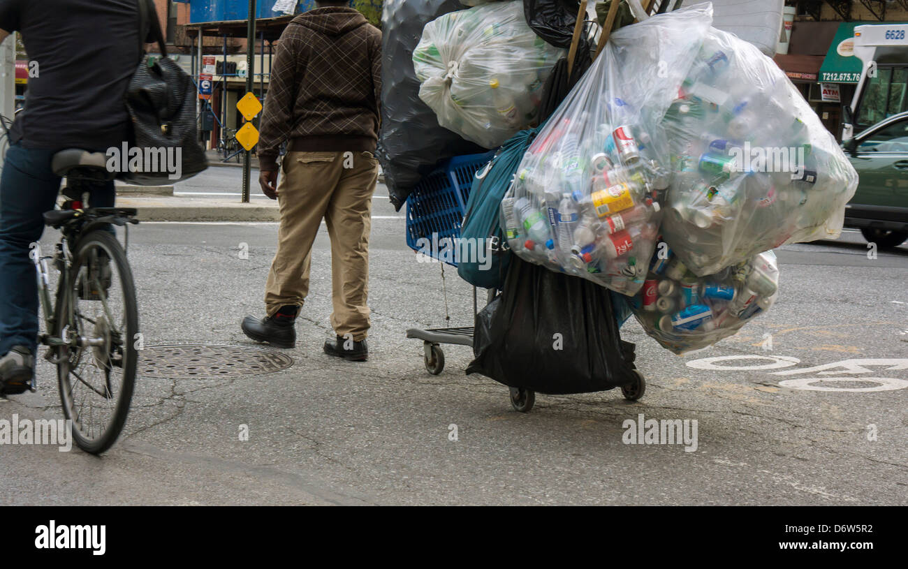 A deposit bottle collector in the bike lane in the Chelsea neighborhood of New York Stock Photo