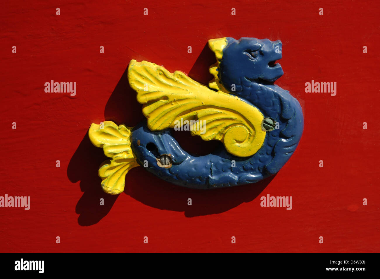 An ornamental ceramic figure in shape of a winged seahorse and vibrant painting decorates a Luzzu traditional fishing boat  from the Maltese islands Stock Photo