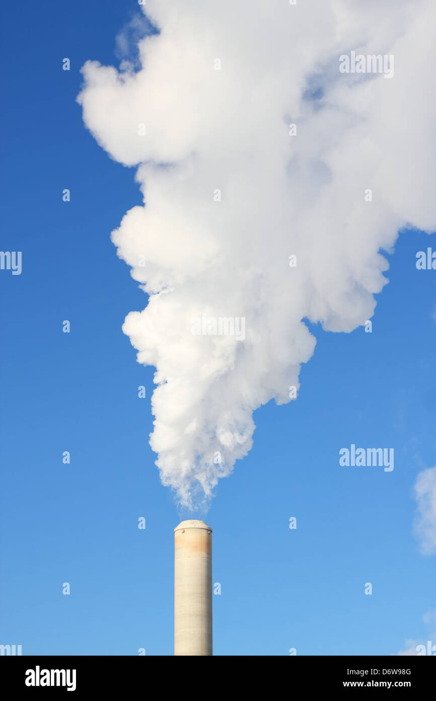 White steam rises out of a stack of a power plant Stock Photo