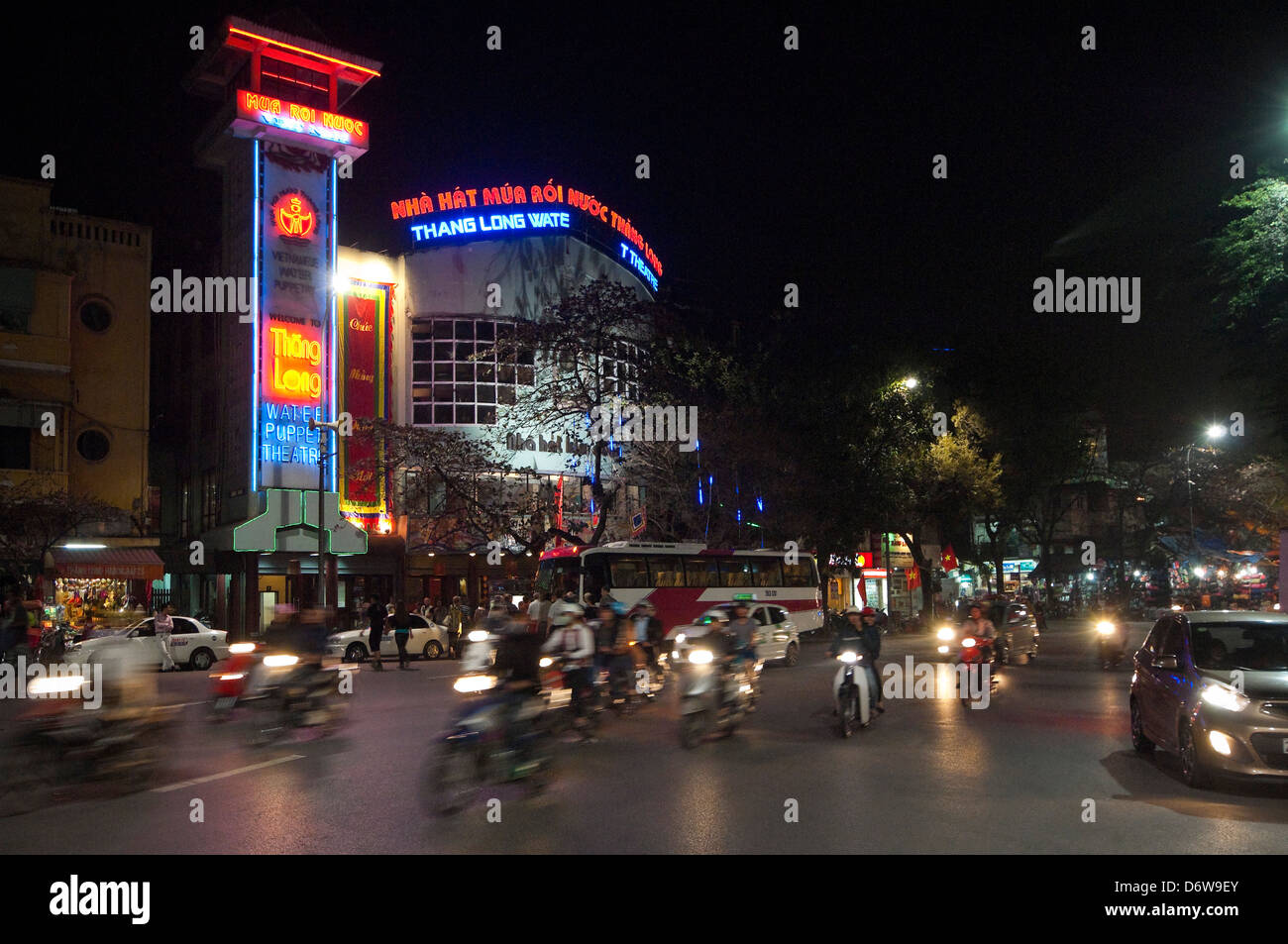 Horizontal nightscape of the exterior of the famous Thang Long water puppet theatre in Hanoi with traffic driving passed. Stock Photo