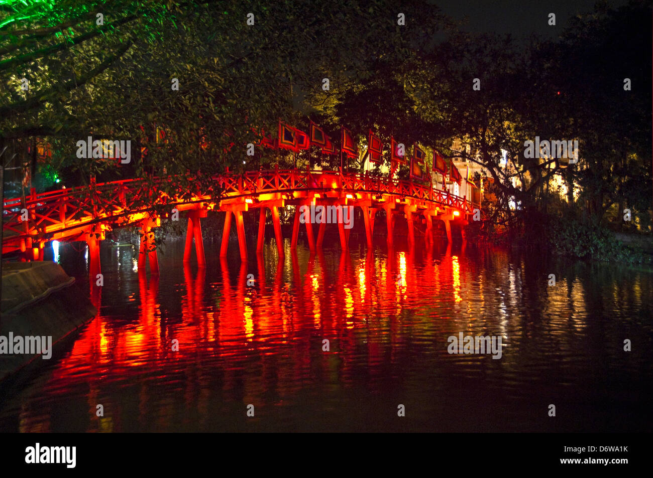 Horizontal wide angle view of The Huc bridge, Thê Húc bridge crossing Hoan Kiem Lake in Hanoi at night. Stock Photo